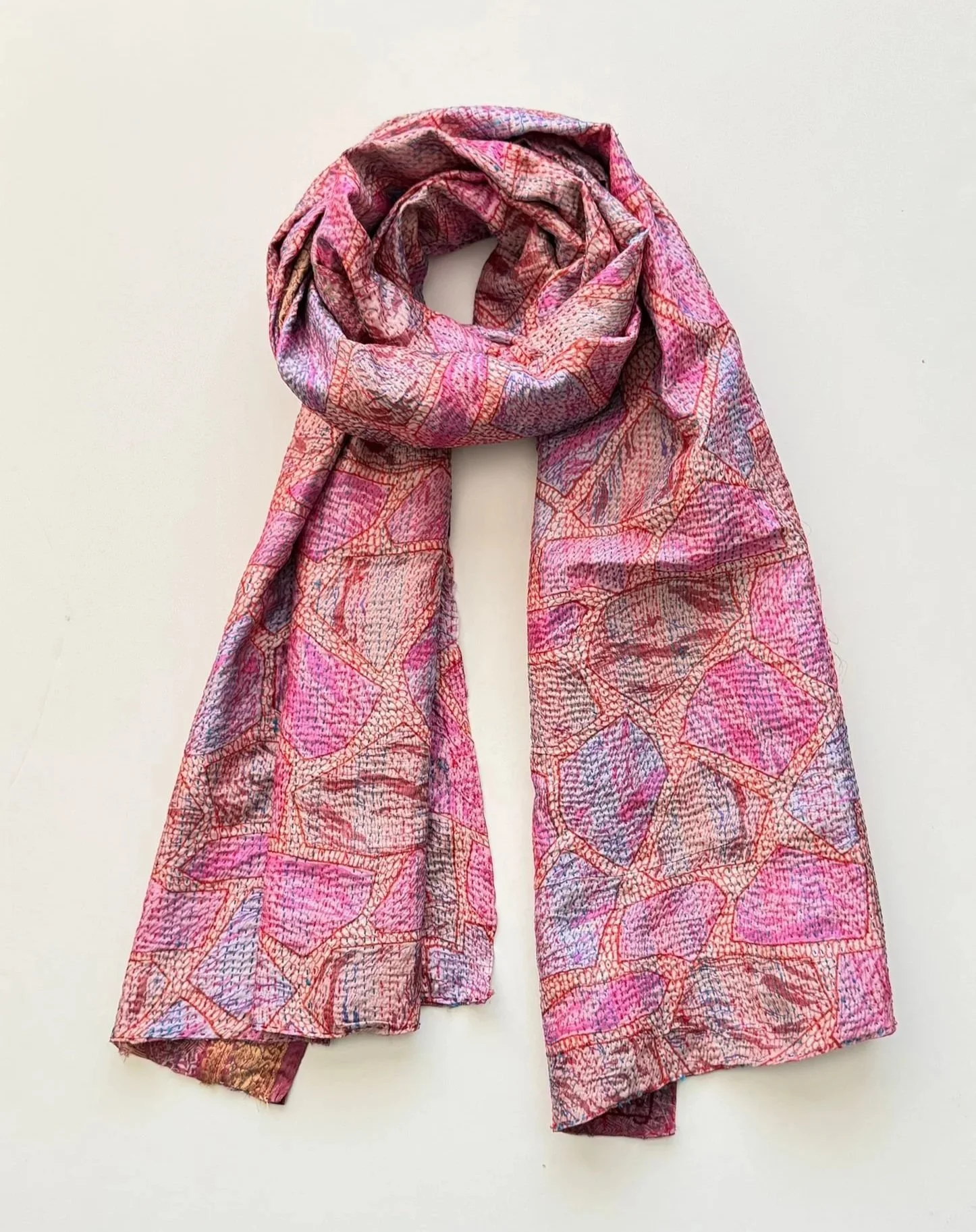 An abstract print upcycled sari kantha scarf draped as flat lay on a white background