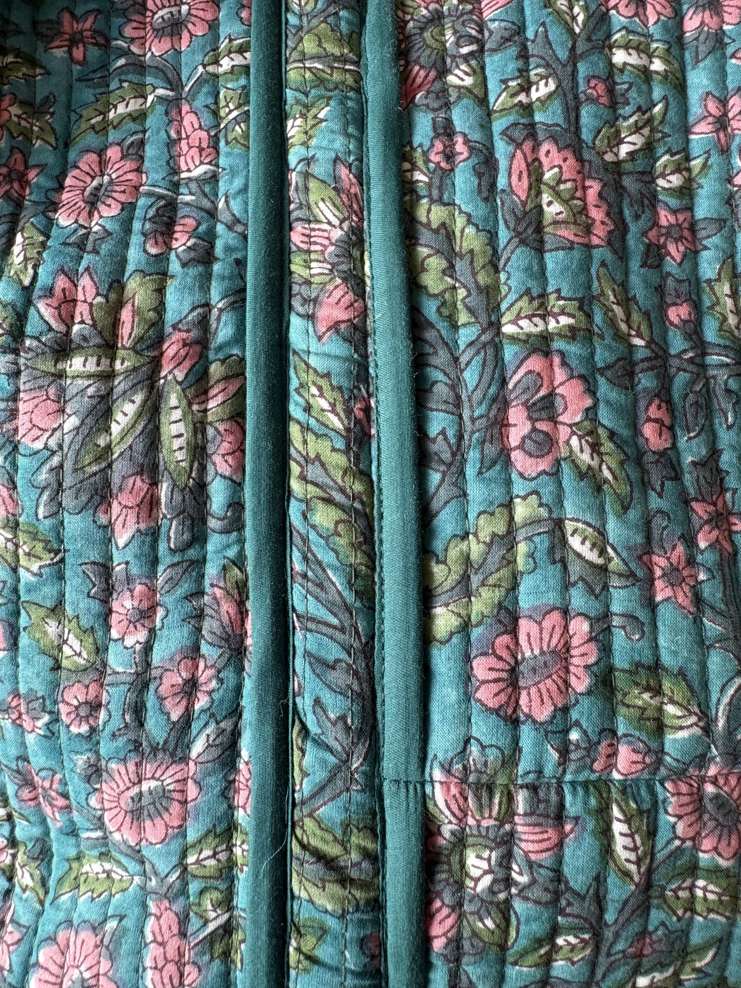 Close up of block print floral design and teal green trims on a quilted cotton tote shopper
