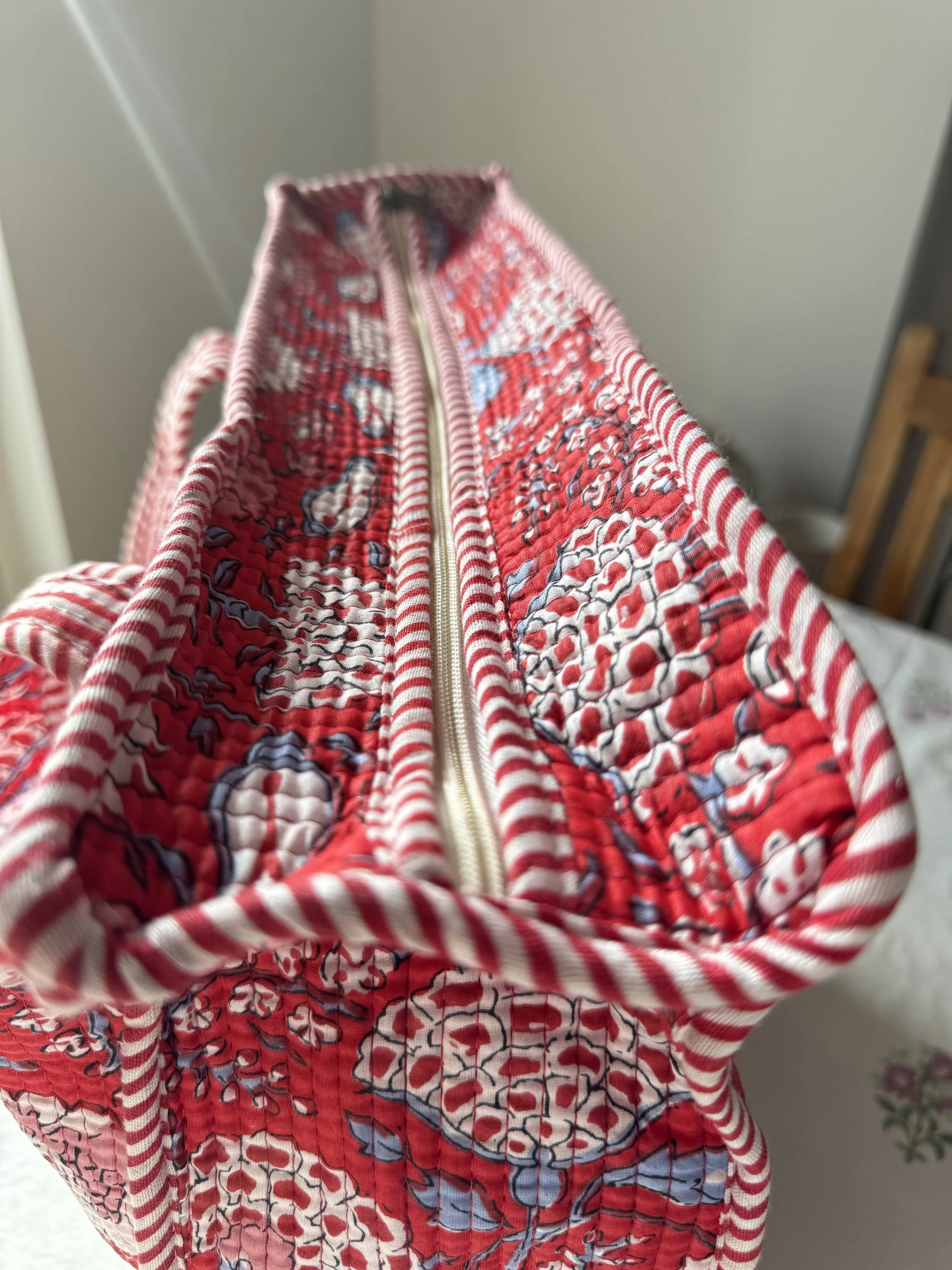 Zip closure on a vibrant red floral summer holiday shopper bag