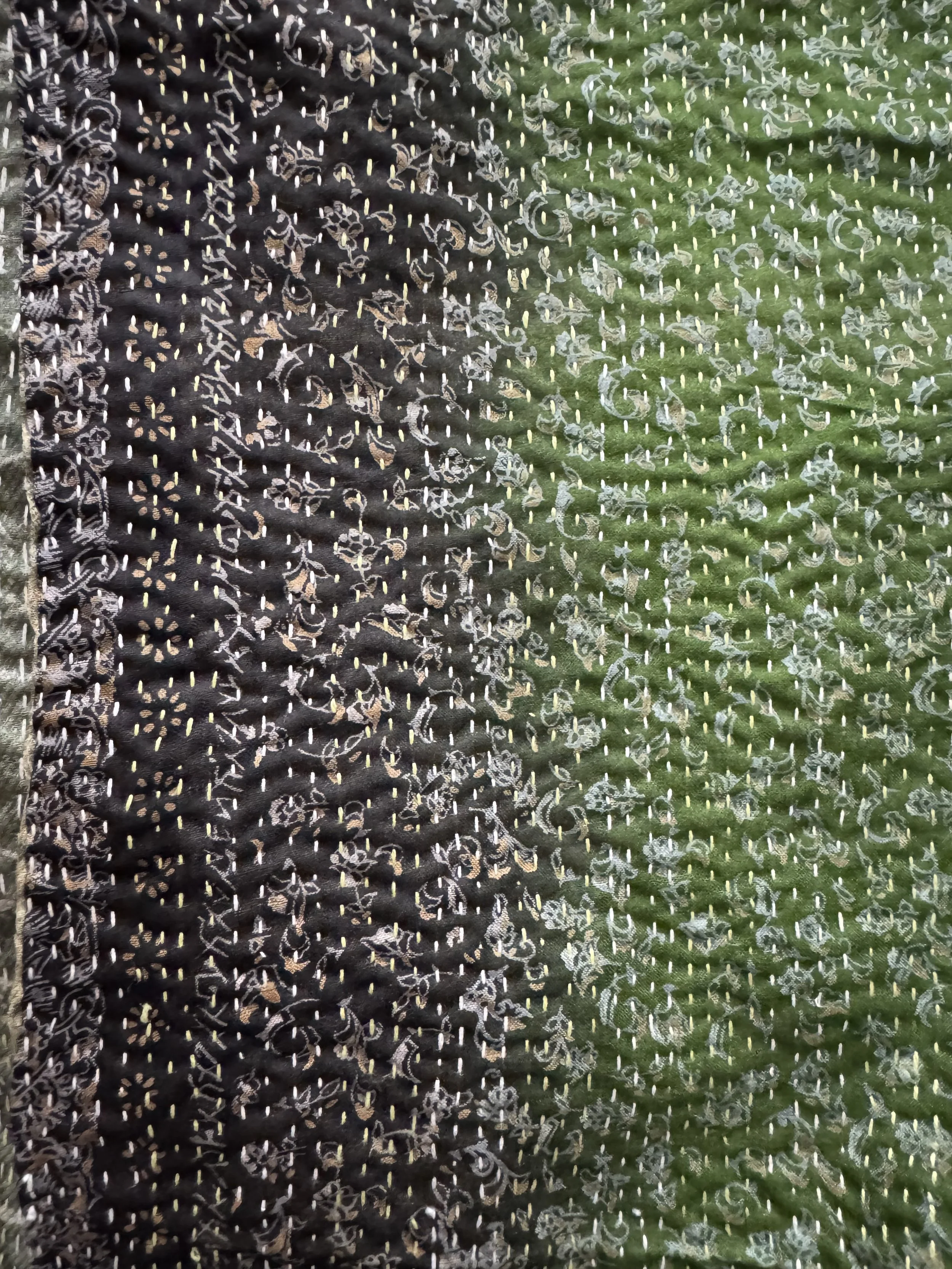 Close up of kantha stitch on a green and charcoal grey sari silk fabric