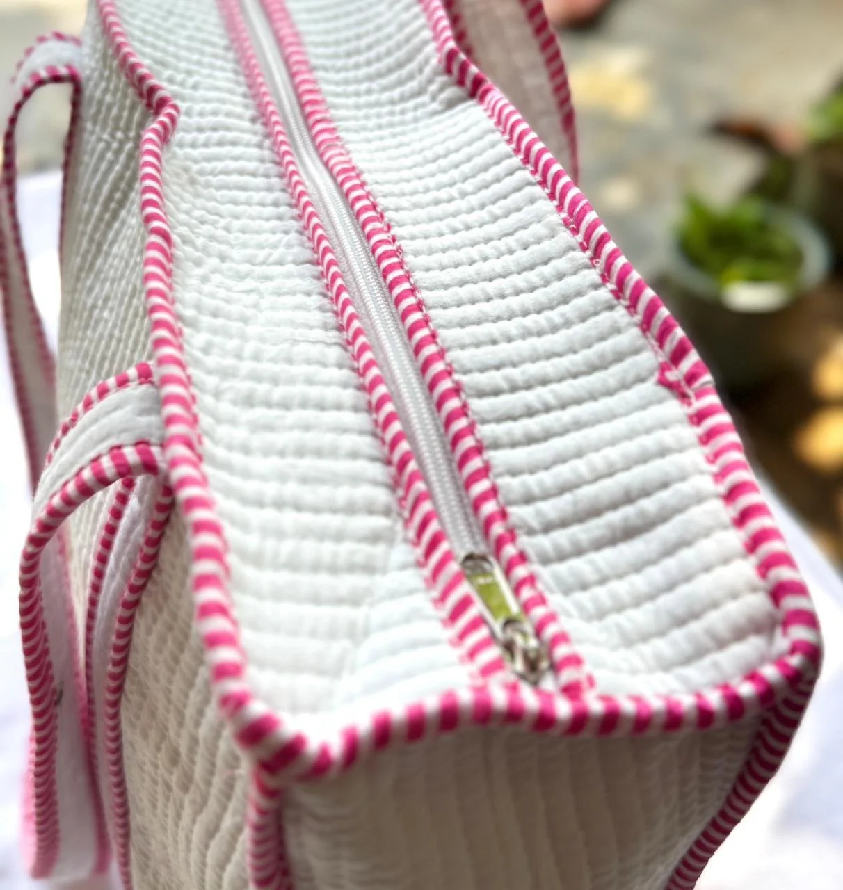Close up of a zip on a pink and cream striped quilted cotton tote bag