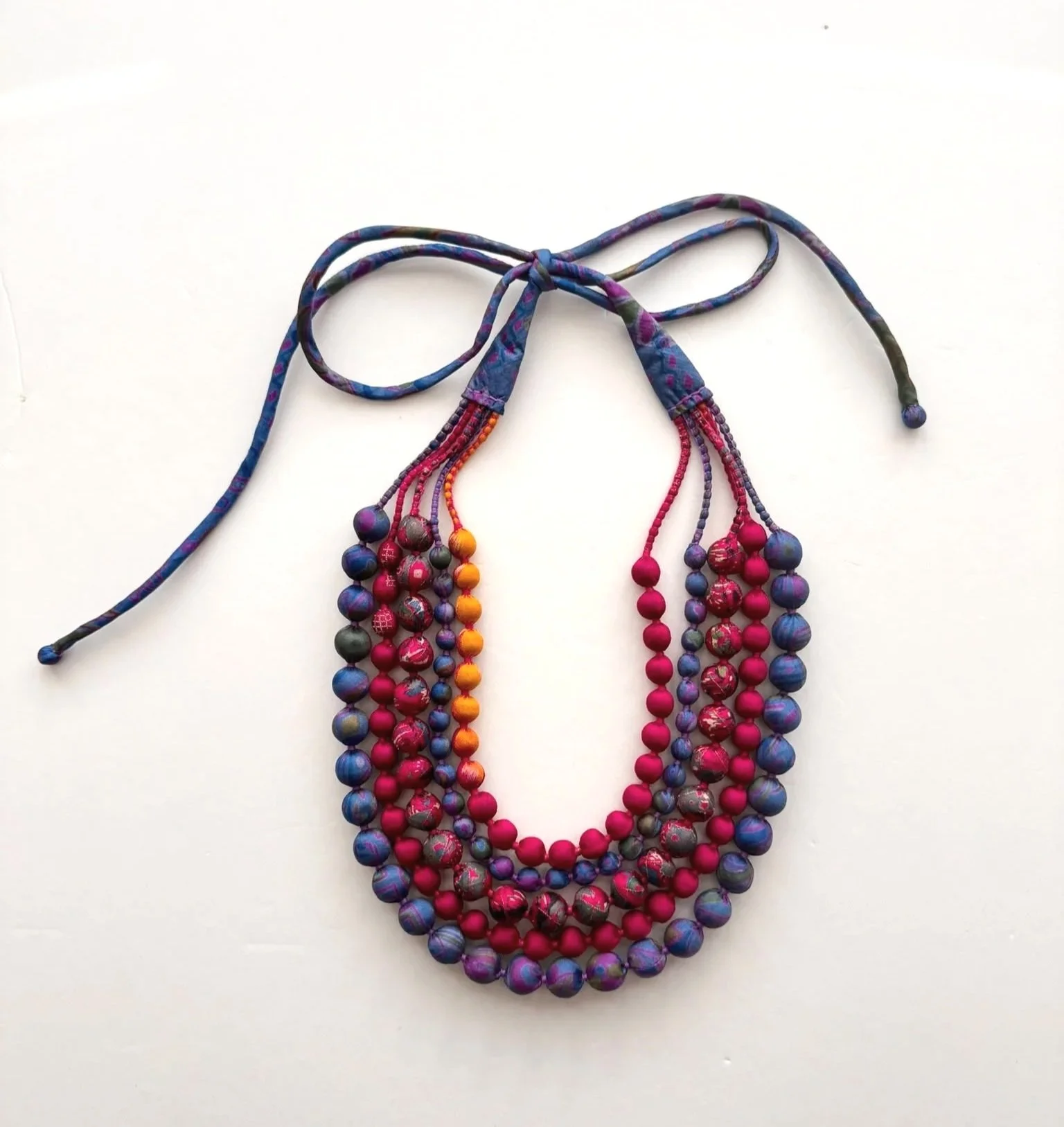 Colourful upcycled sari beaded necklace on a white background