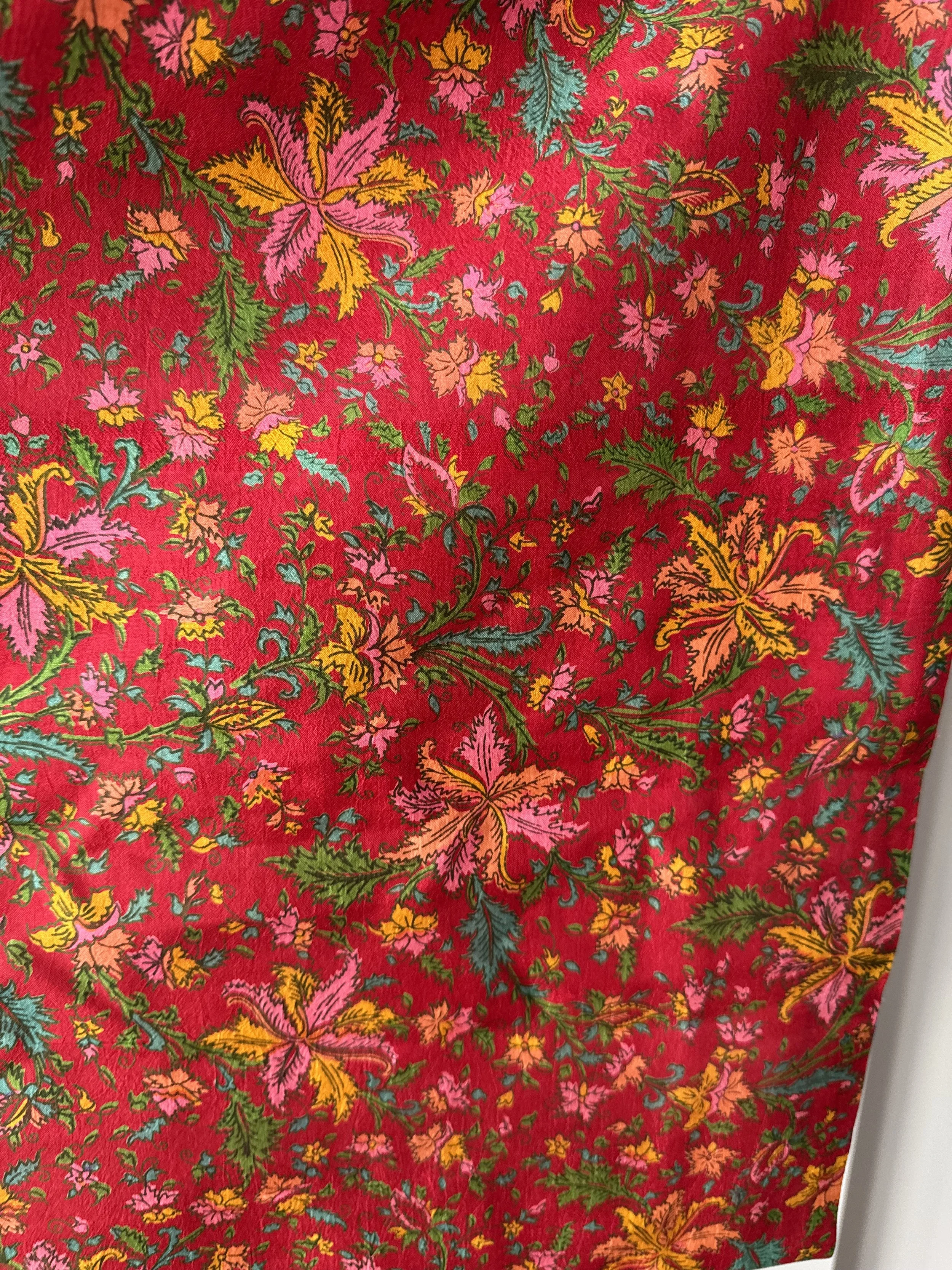 Close up floral upcycled sari silk fabric in red with colourful botanical print