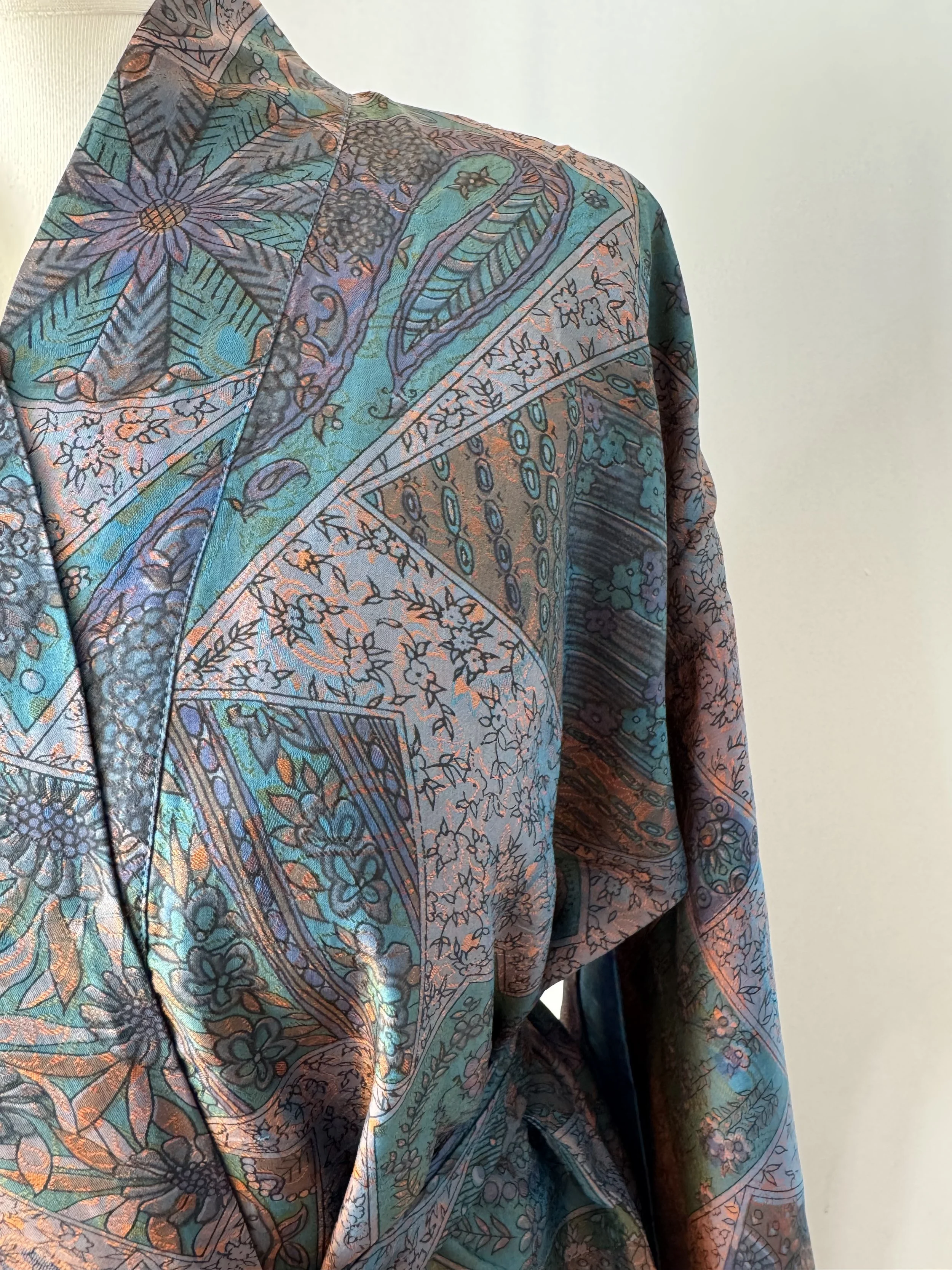 Close up of floral silk sari kimono robe in aubergine and teal, crafted from select recycled sari silk and handmade by artisans in India