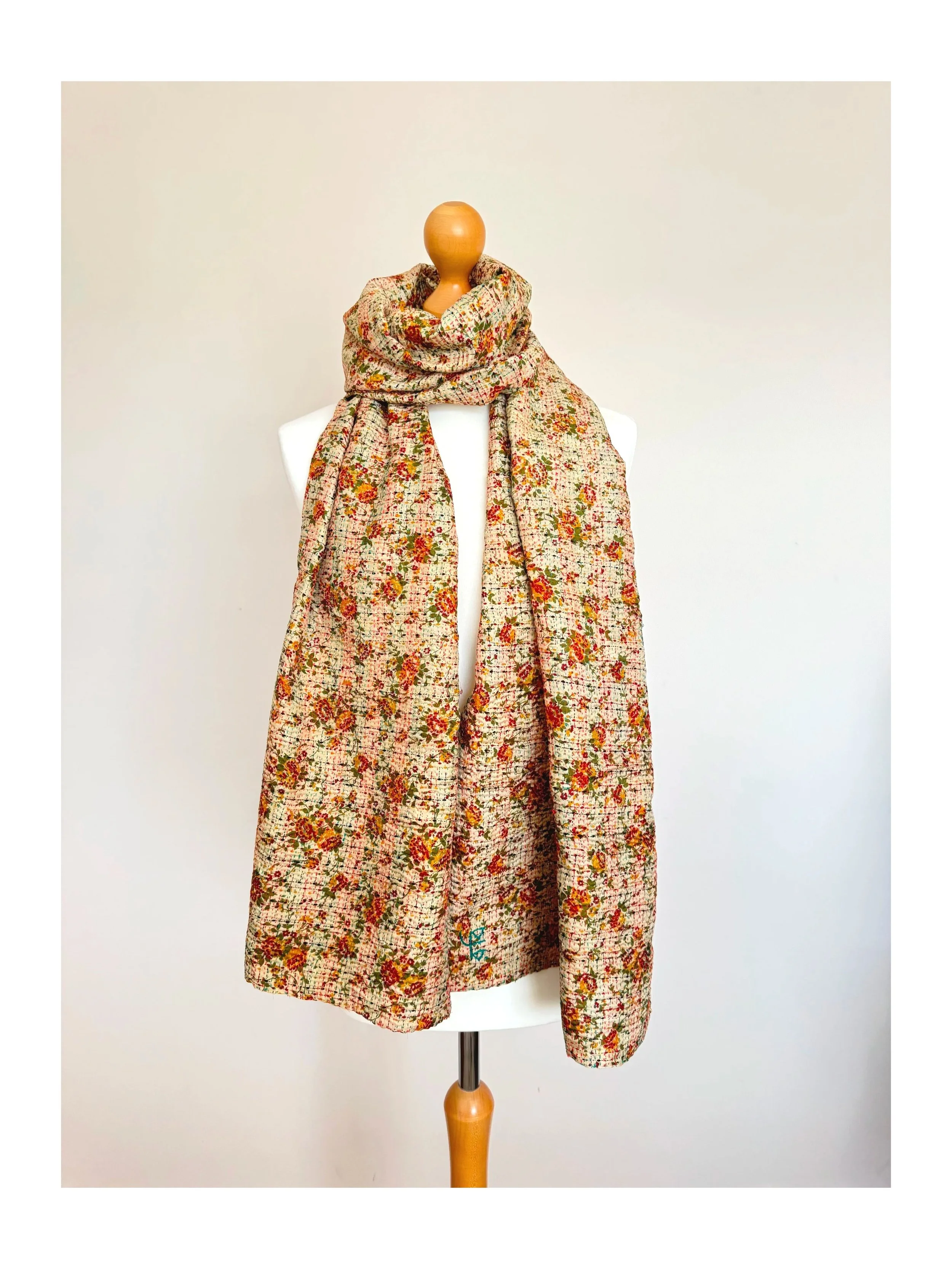 A floral silk scarf made from preloved sari silk upcycled with kantha stitch against a white background