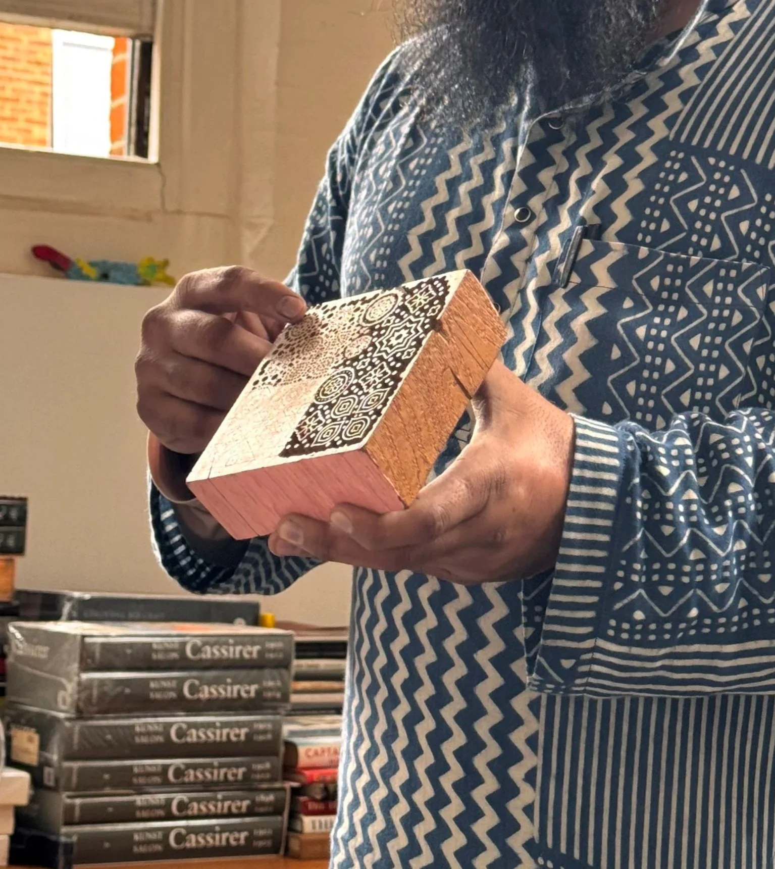 Master artisan Sufiyan Khatri holding up a carved wooden block print