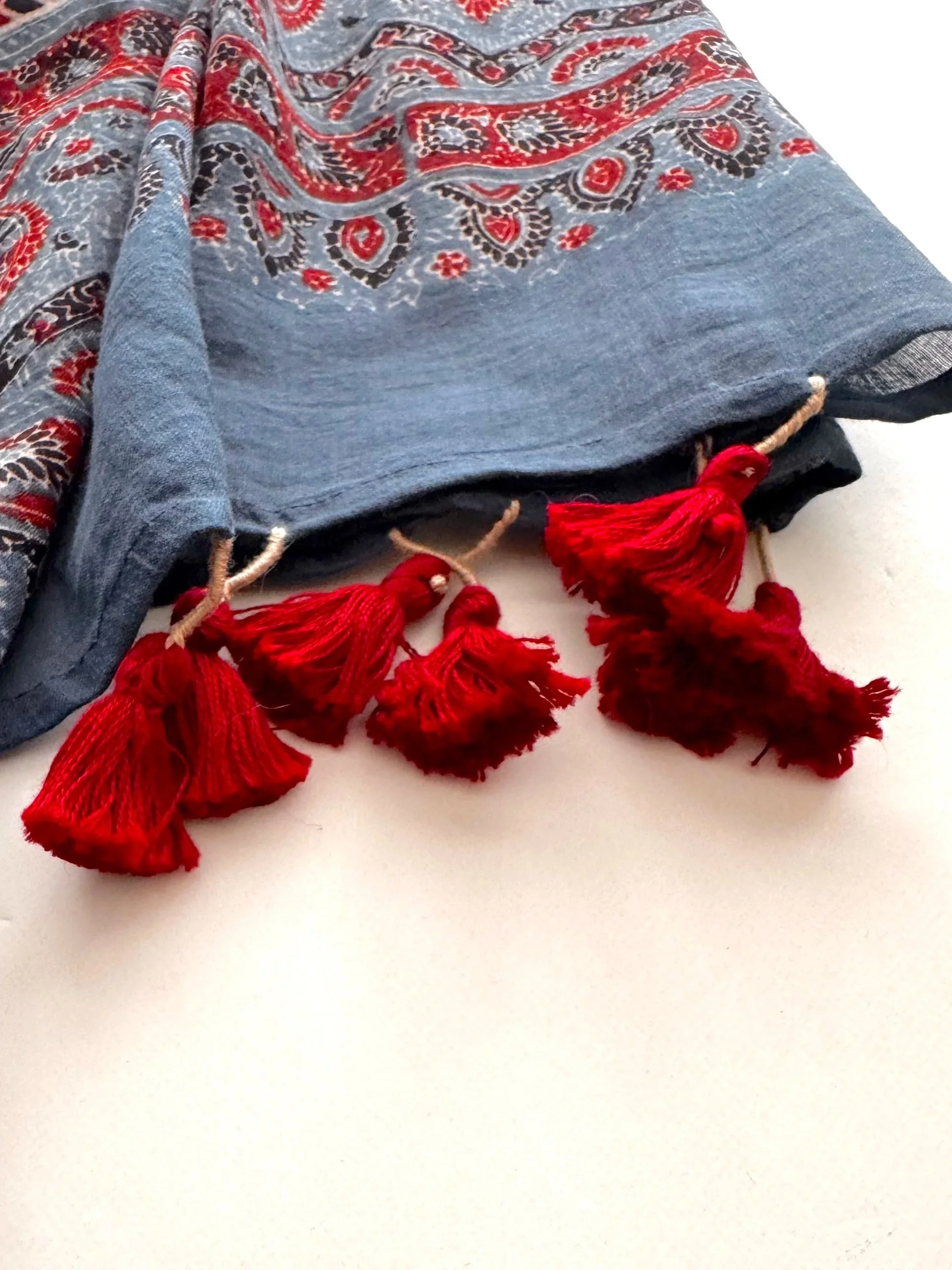 Red hand-knotted tassels on the end of a naturally dyed indigo Ajrakh scarf