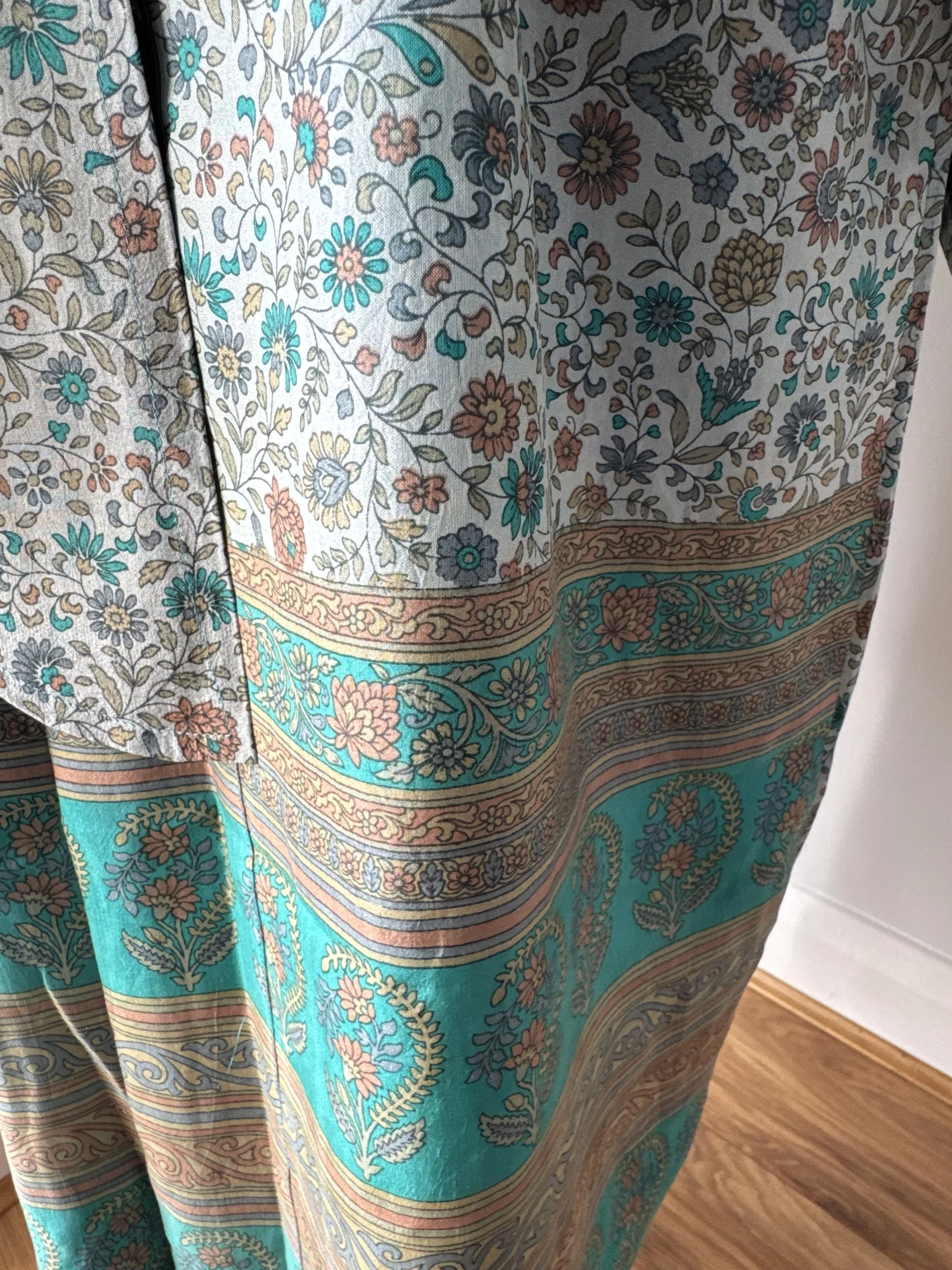 Close up floral long silk kimono dressing with striking paisley border in turquoise