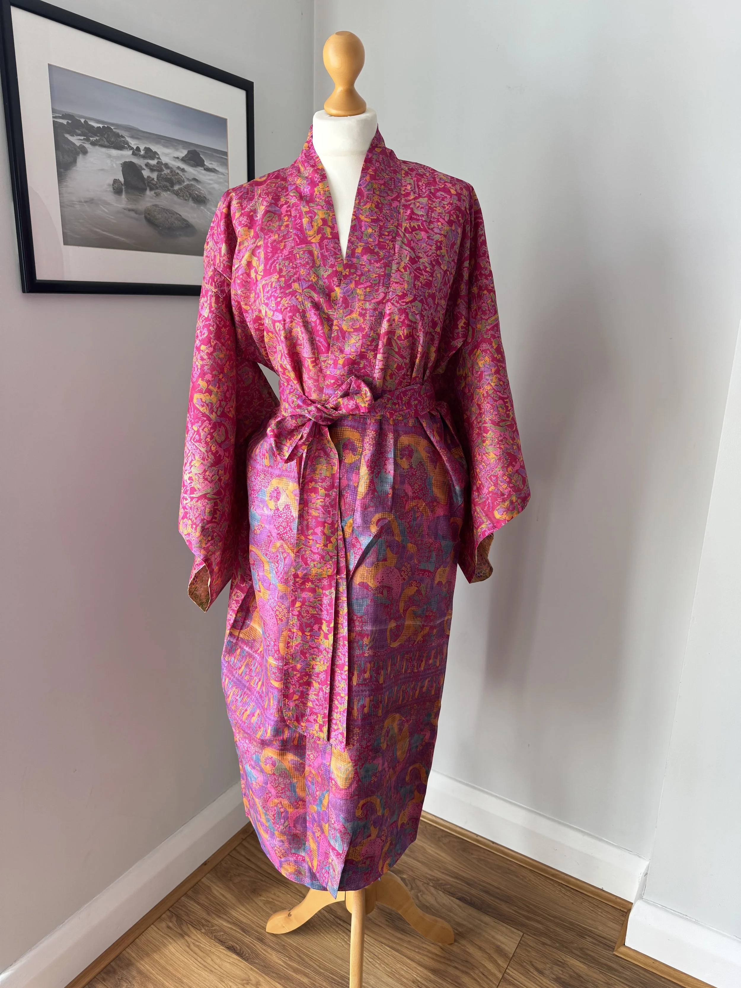Rani pink upcycled sari silk kimono robe with matching silk tie belt, displayed on a dressing mannequin