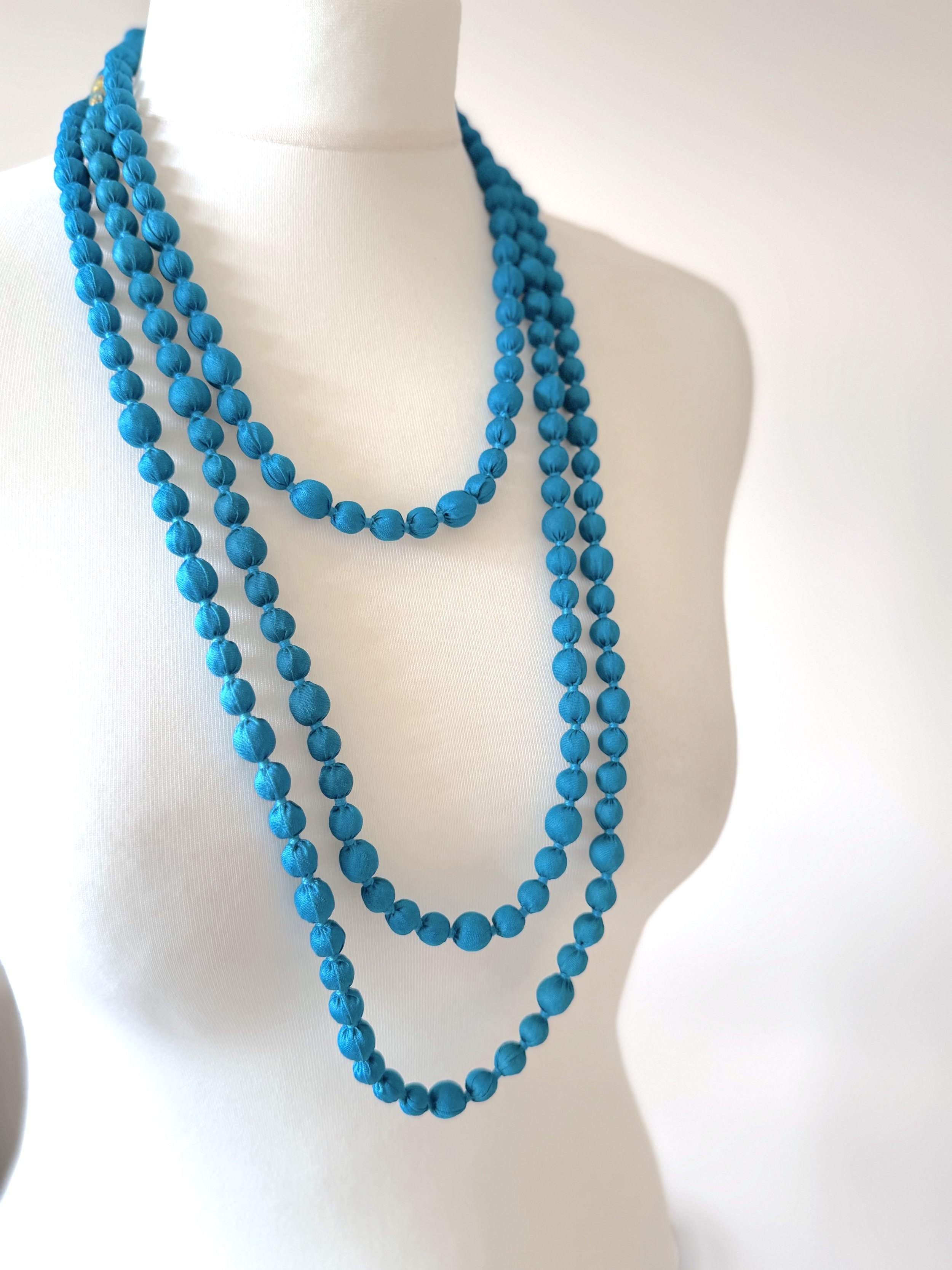 Blue beaded silk fabric necklace in Cyan blue