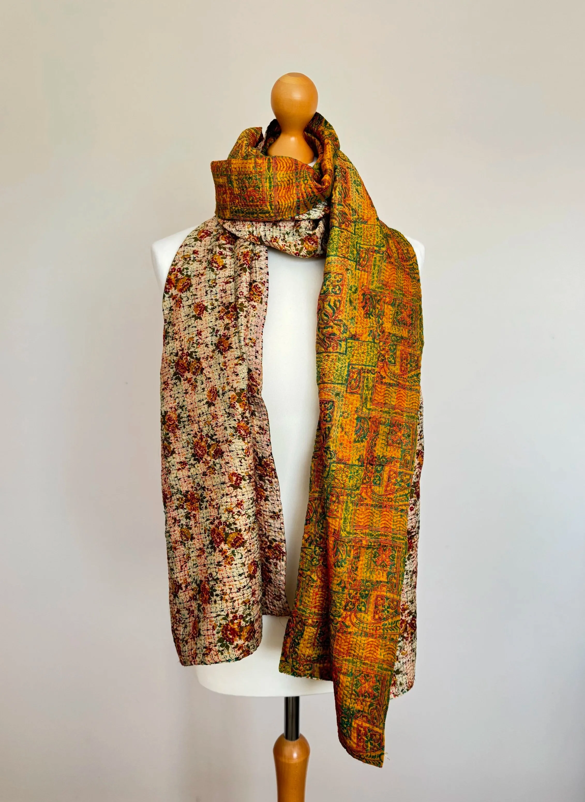 A reversible pattern upcycled sari silk floral scarf draped over a mannequin against a white background