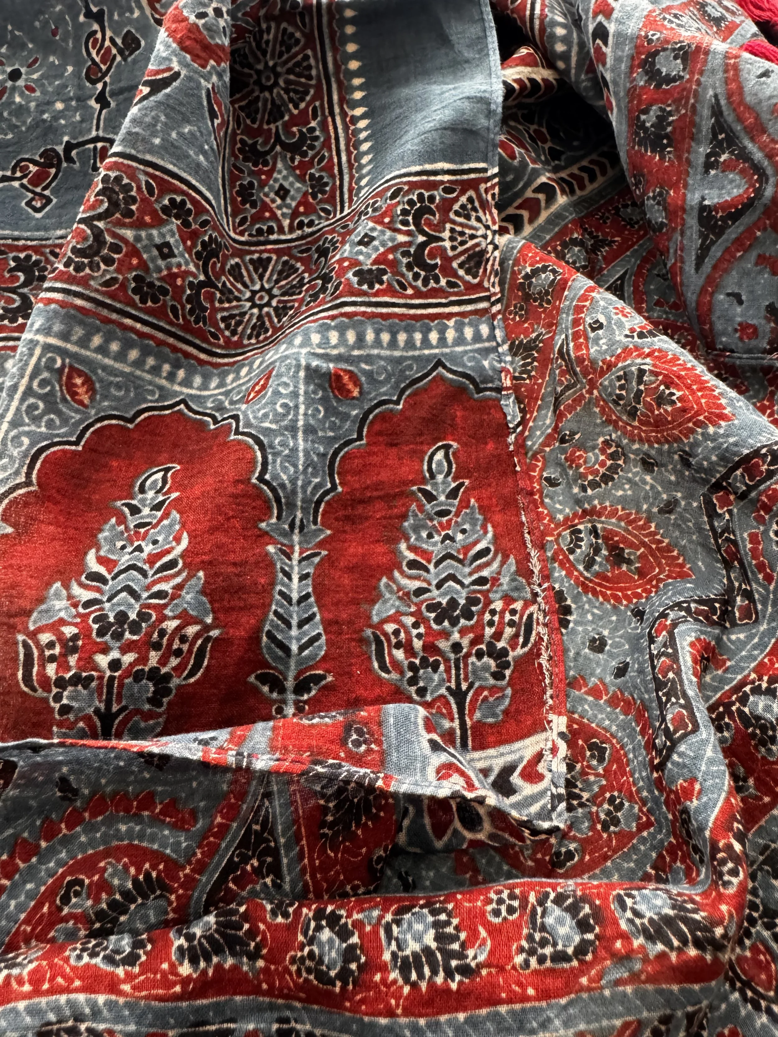 Detail of floral and geometric Ajrakh print in indigo, red, black and cream on a handmade cotton scarf