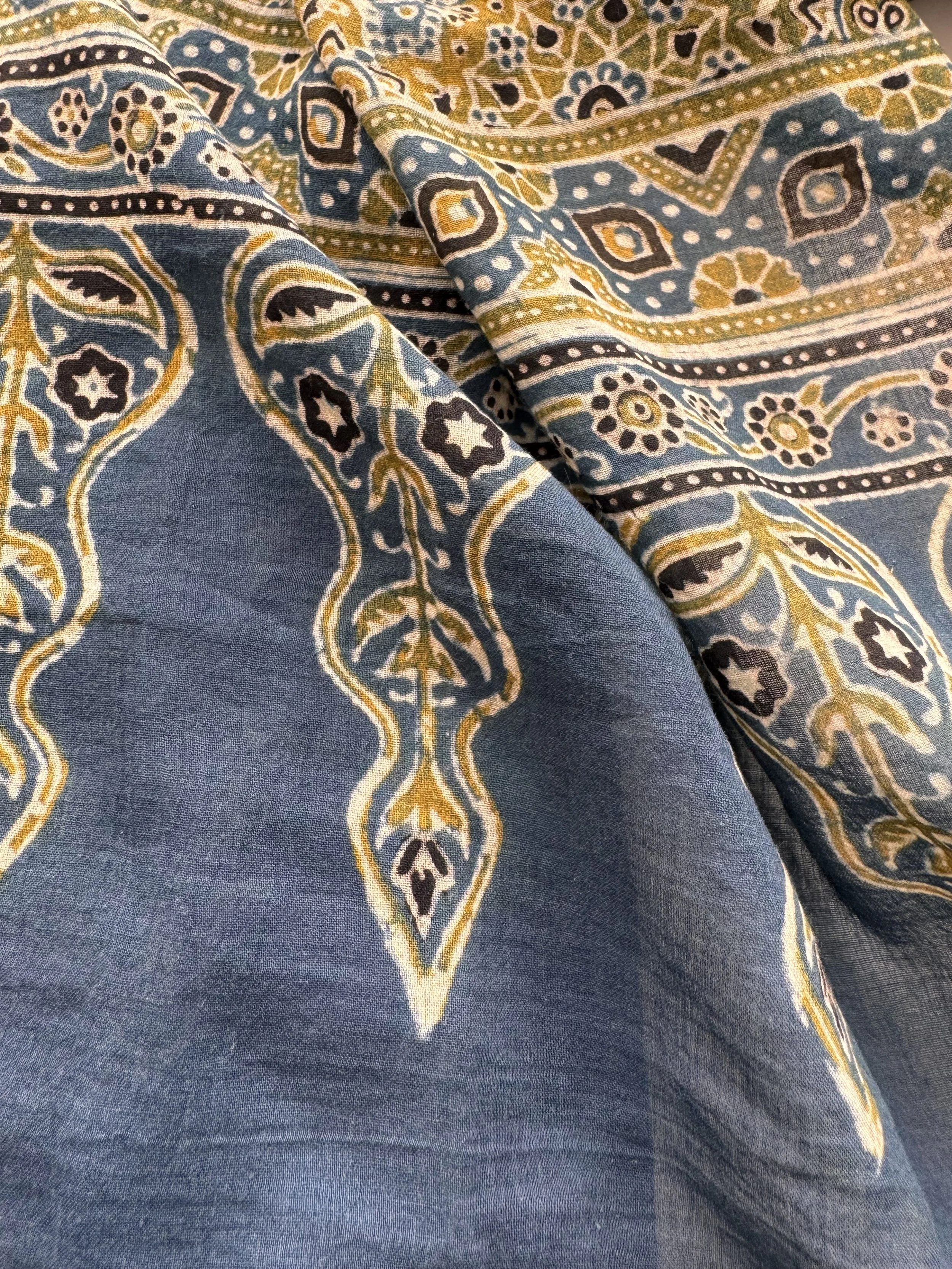 Close-up of intricate Ajrakh medallion and star pattern in indigo, olive and black on soft cotton