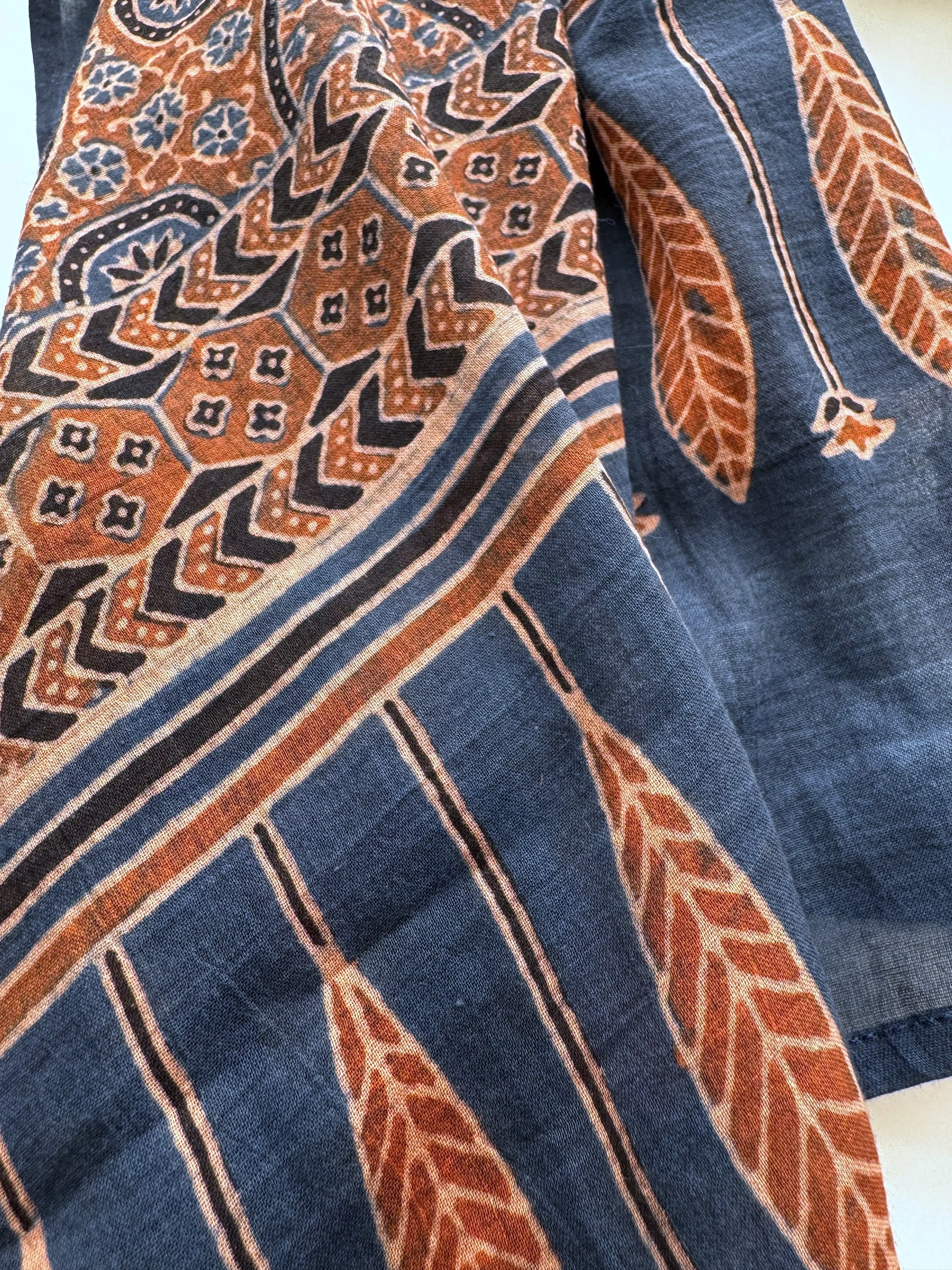 Row of rust red leaf motifs on the indigo end of an Ajrakh block printed shawl