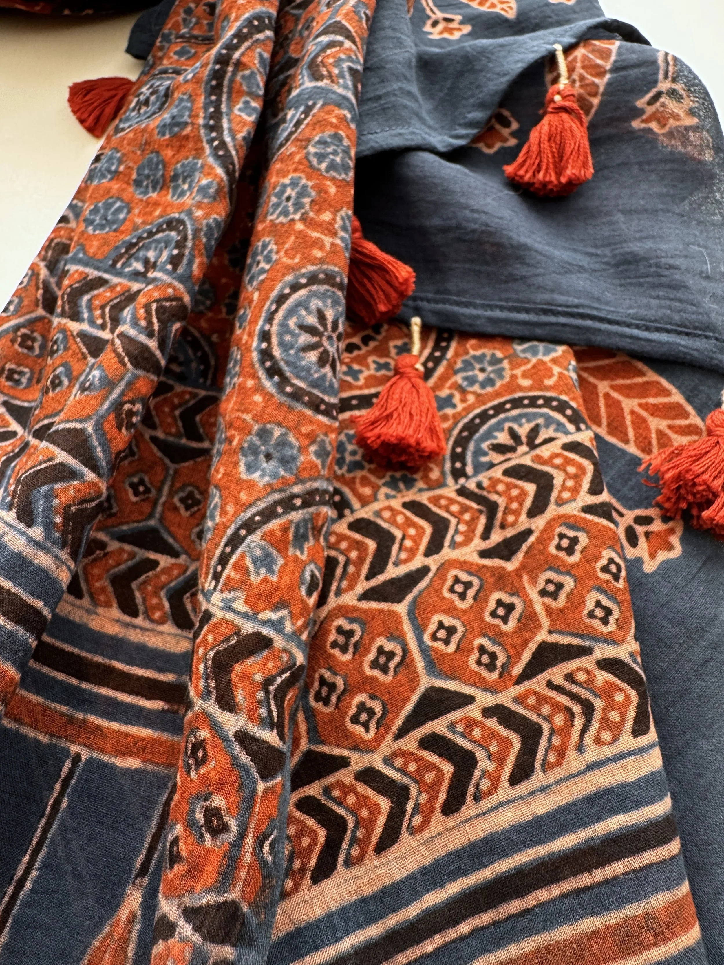Close-up of rust red and indigo Ajrakh medallion and chevron border on soft cotton