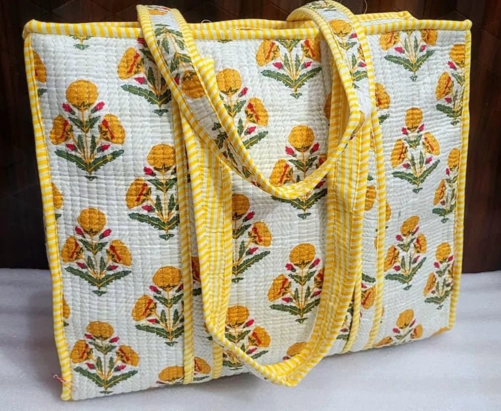 A yellow floral print quilted cotton tote bag