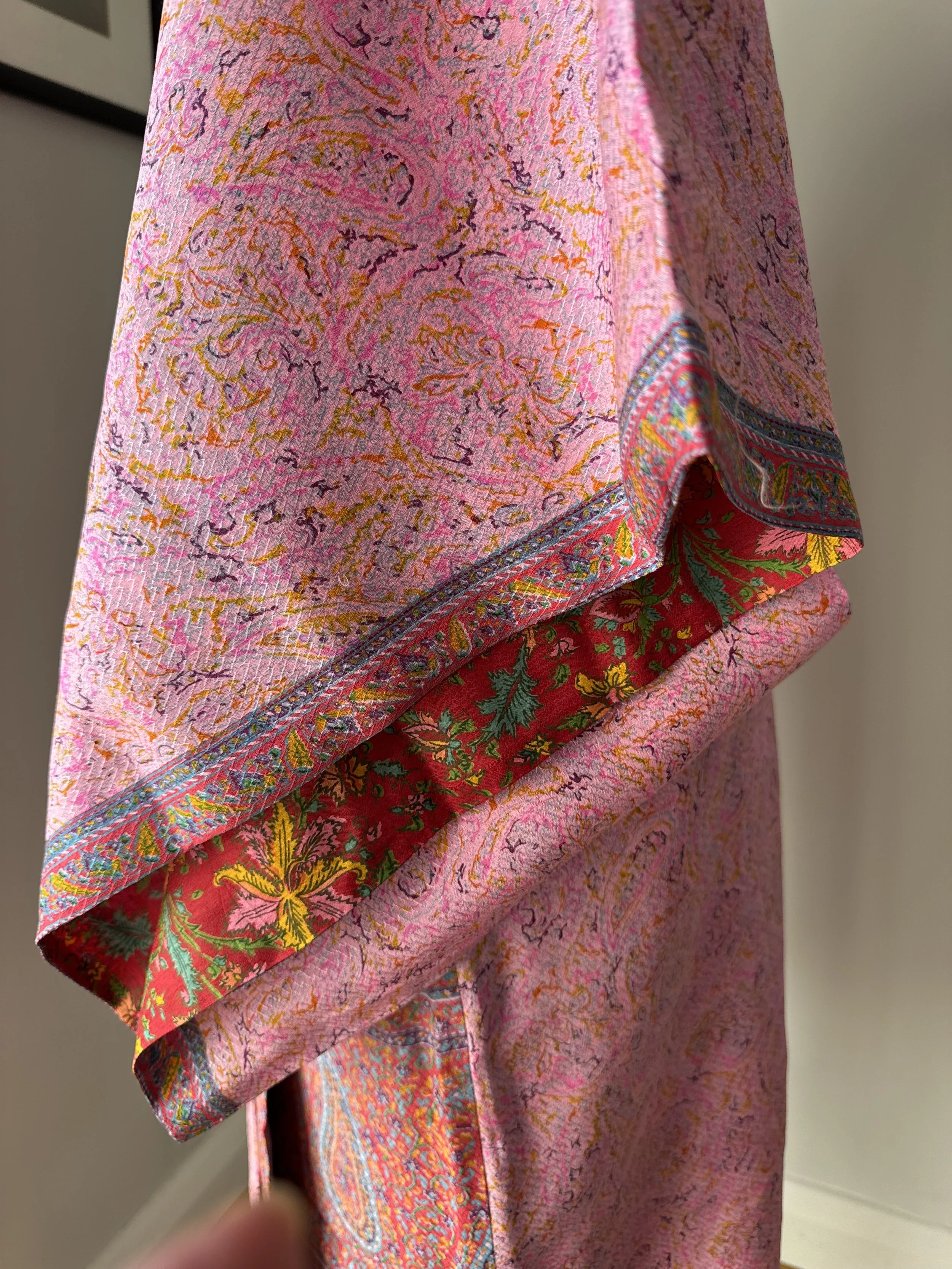 Close up of pink silk kimono sleeves with contrasting colourful floral lining in red, yellow, pink and green