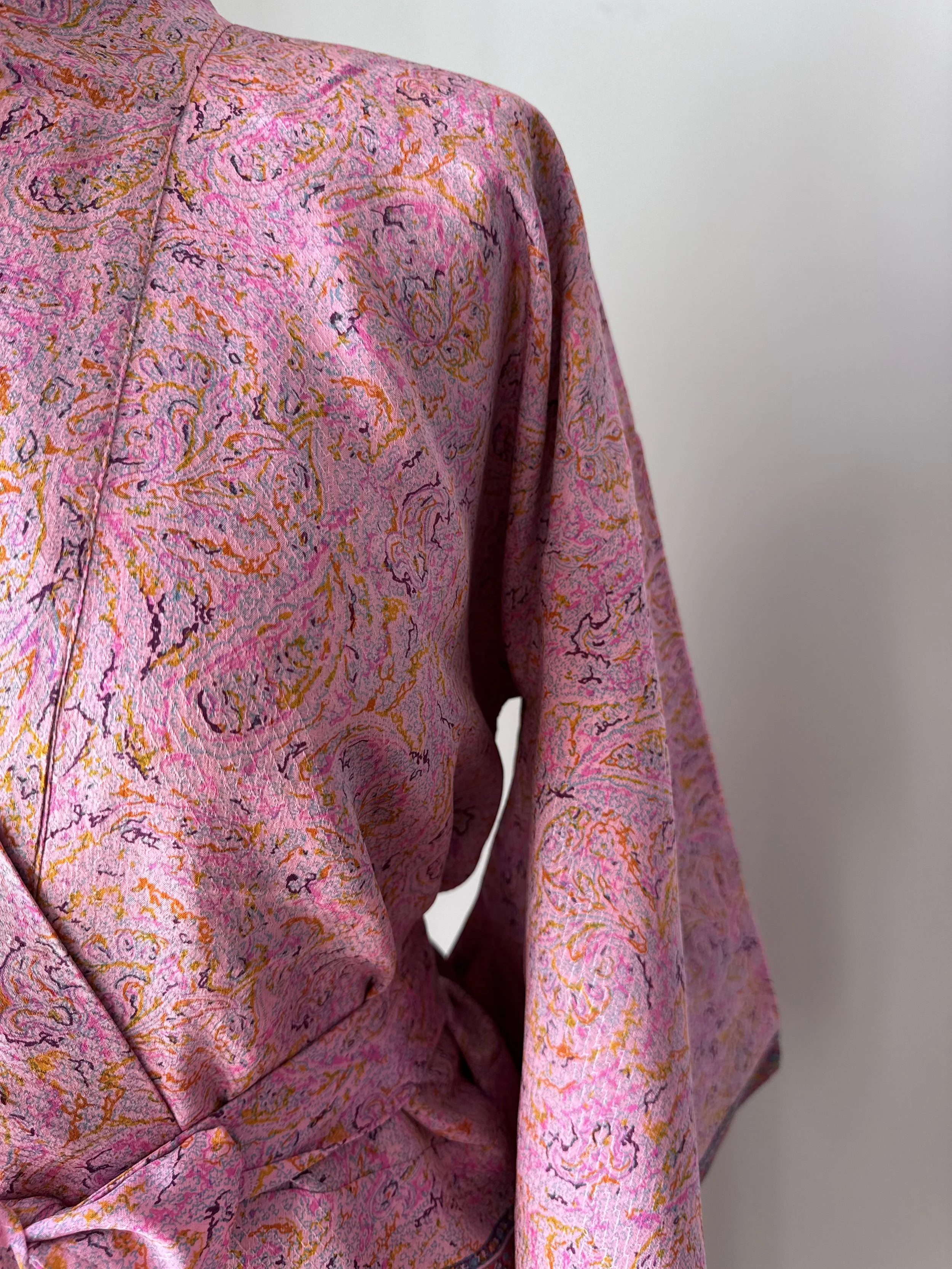 Close up of pink silk bathrobe handmade from recycled sari silk with paisley print