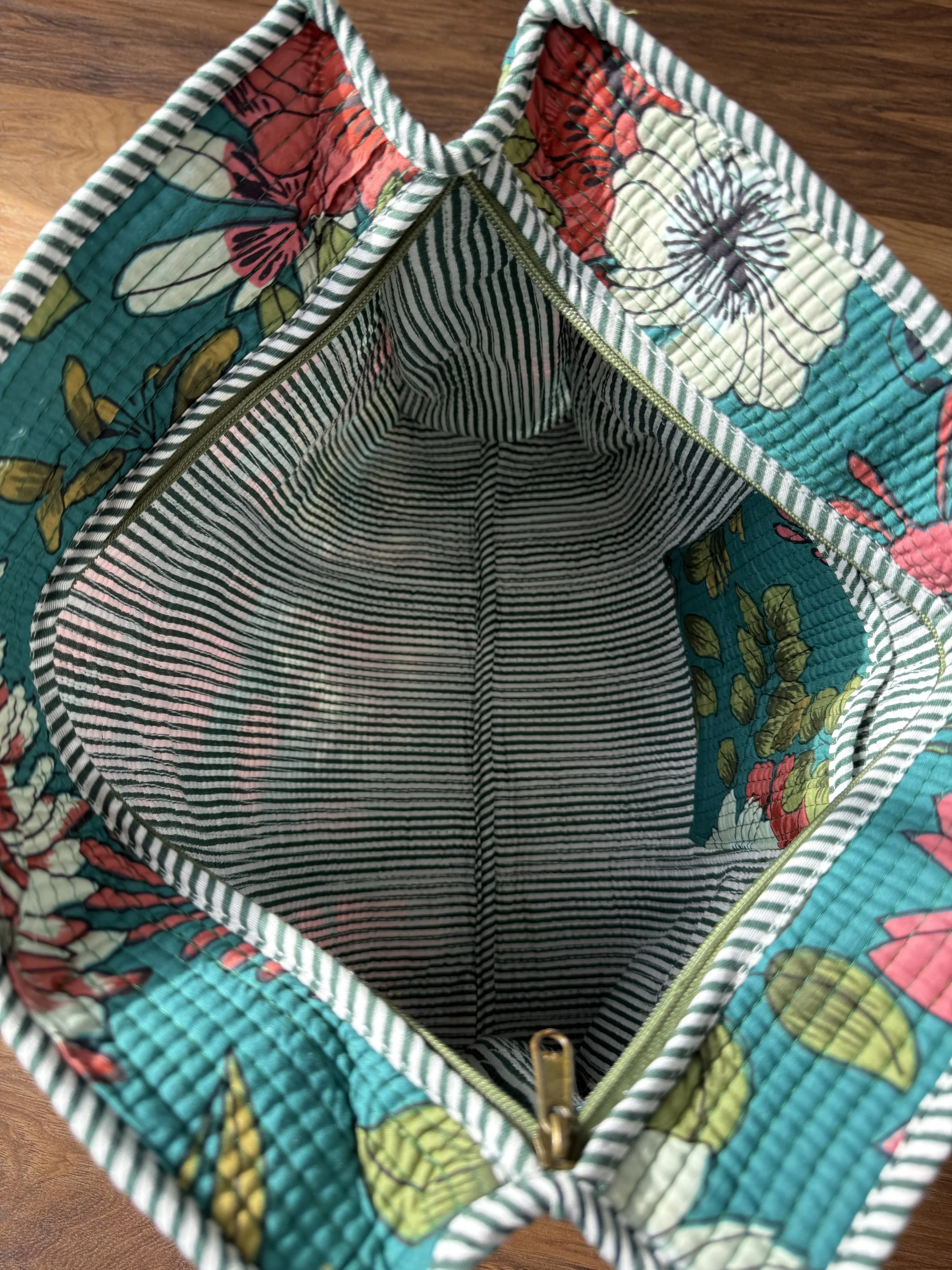 Inside of large handmade quilted tote bag with striped inside lining and floral inside pocket