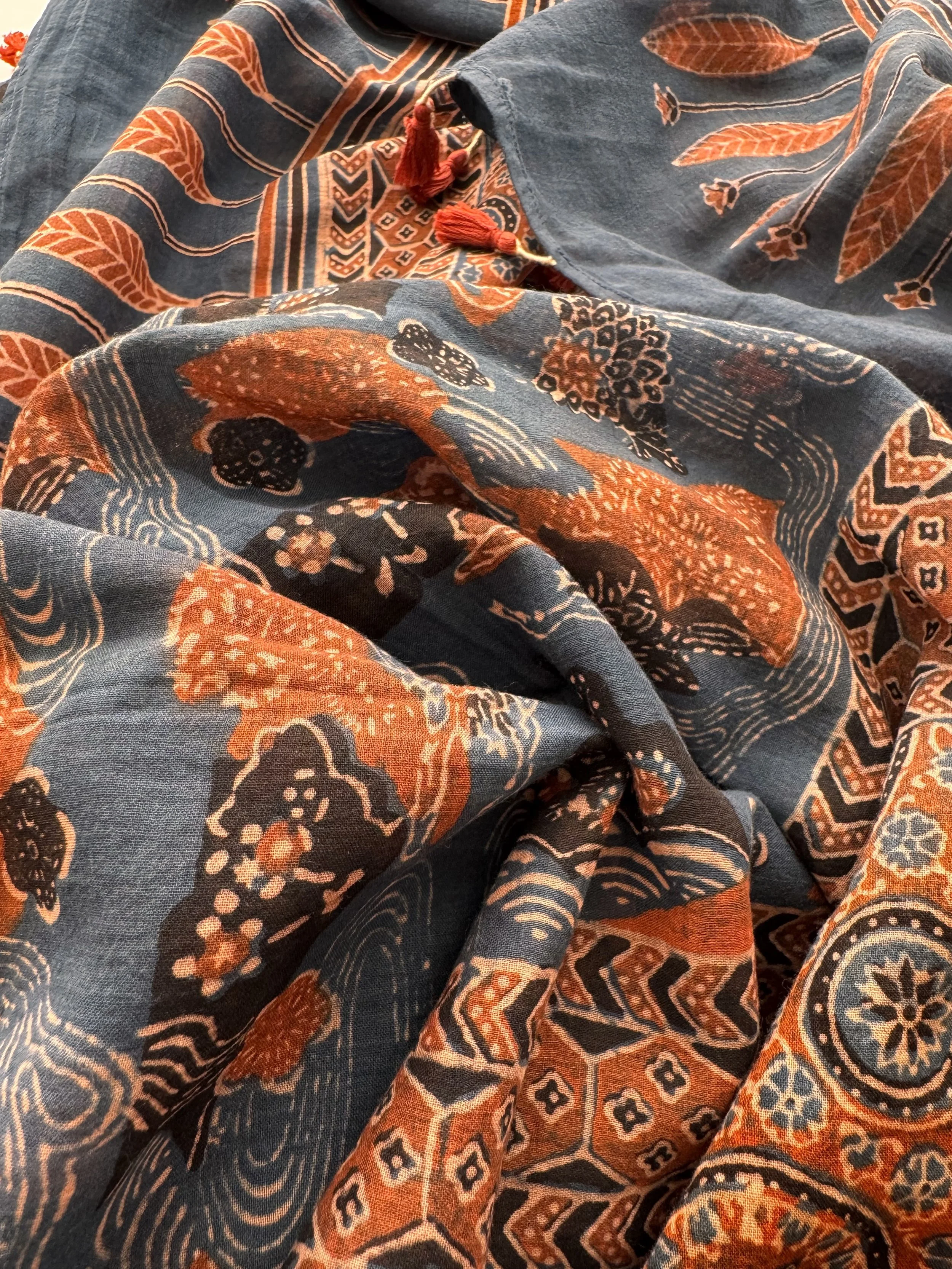 Close-up of rust red and indigo Ajrakh patterns on a cotton shawl