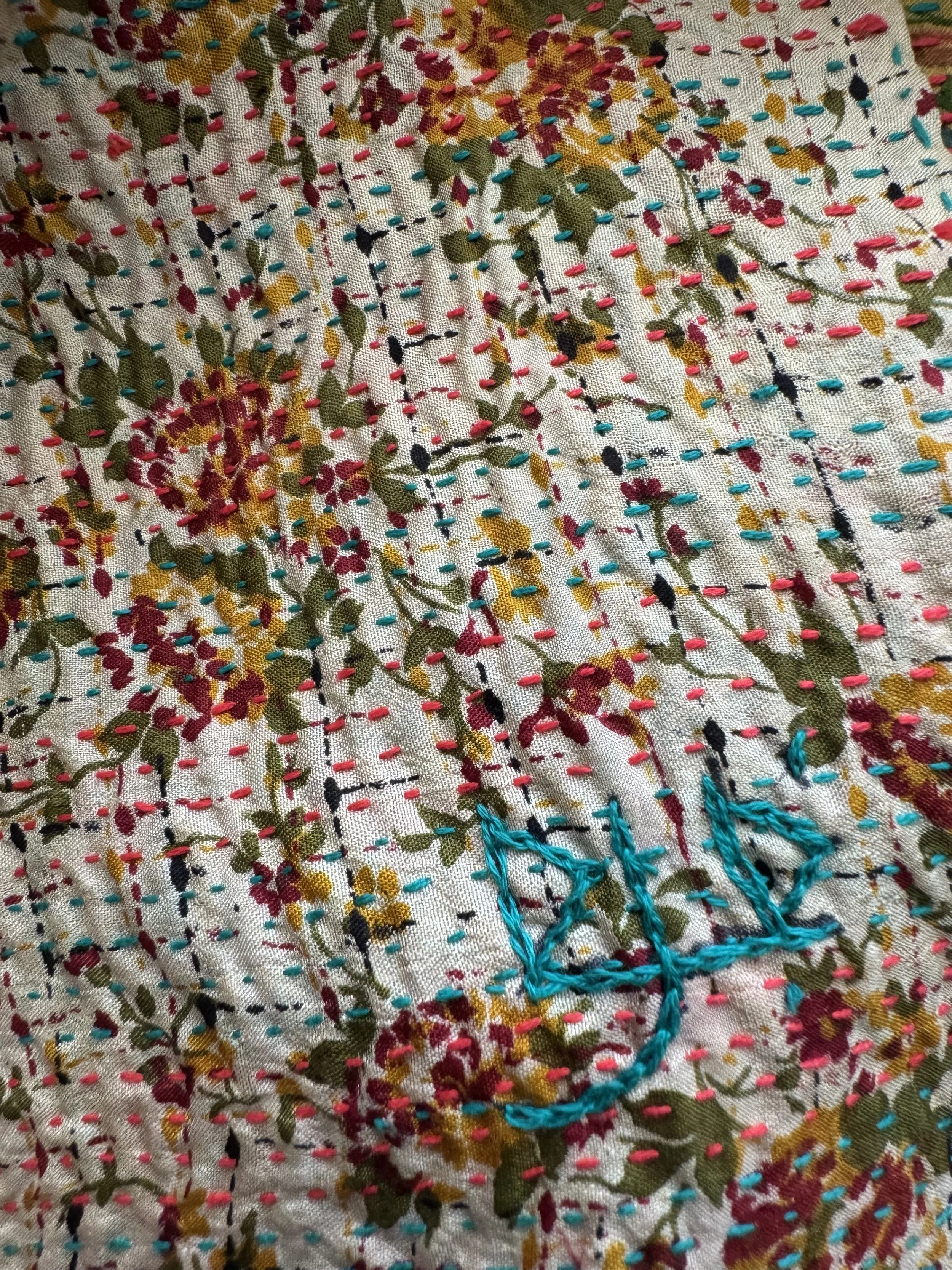 A richly textured sari silk fabric embroidered with kantha running stitch and adorned with the signature of the maker