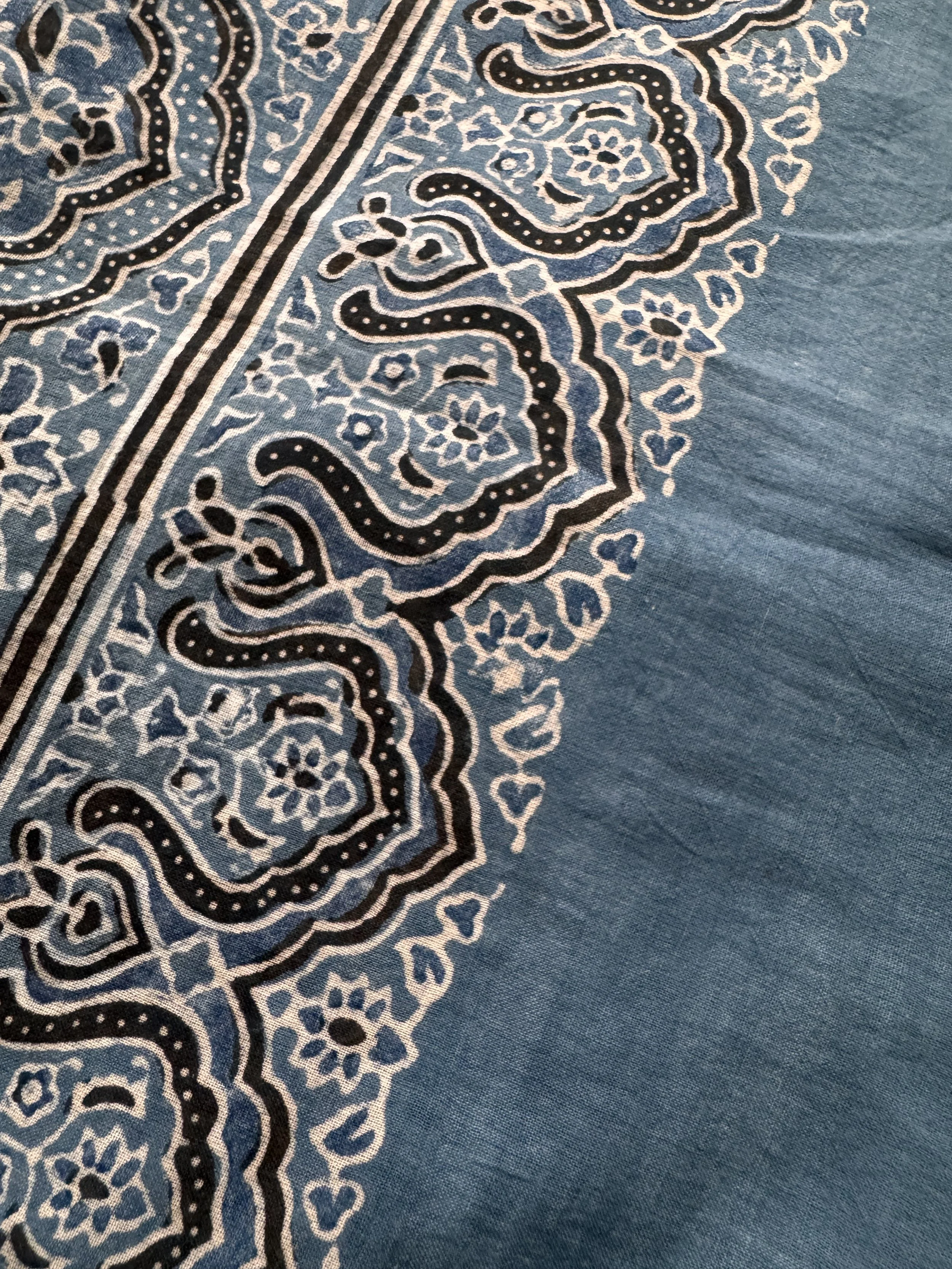 Close-up of Ajrakh block print border on indigo cotton scarf with black and white scalloped motifs