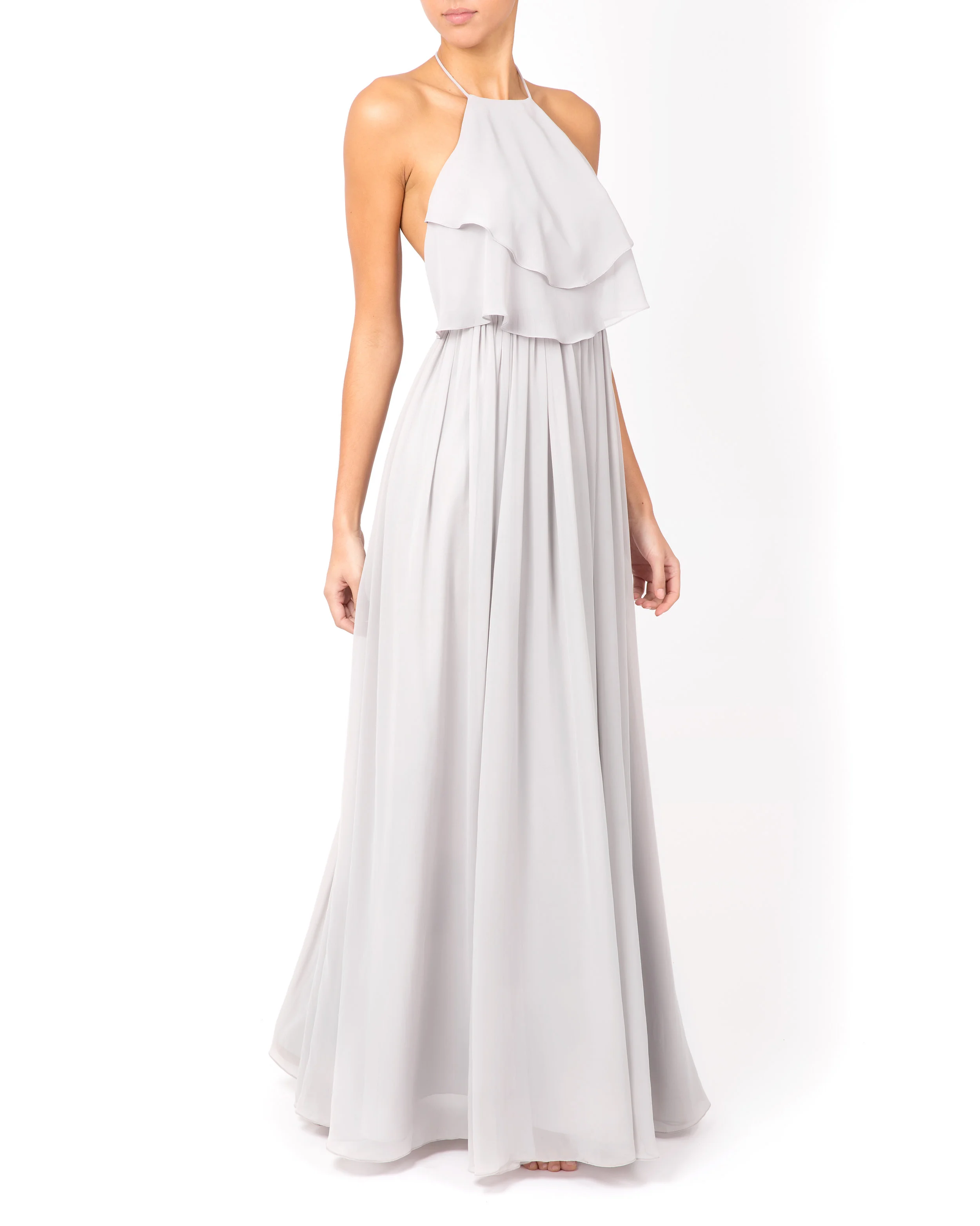 Model steps forwards with shoulders back wearing floor-length dress with ruffled bodice.
