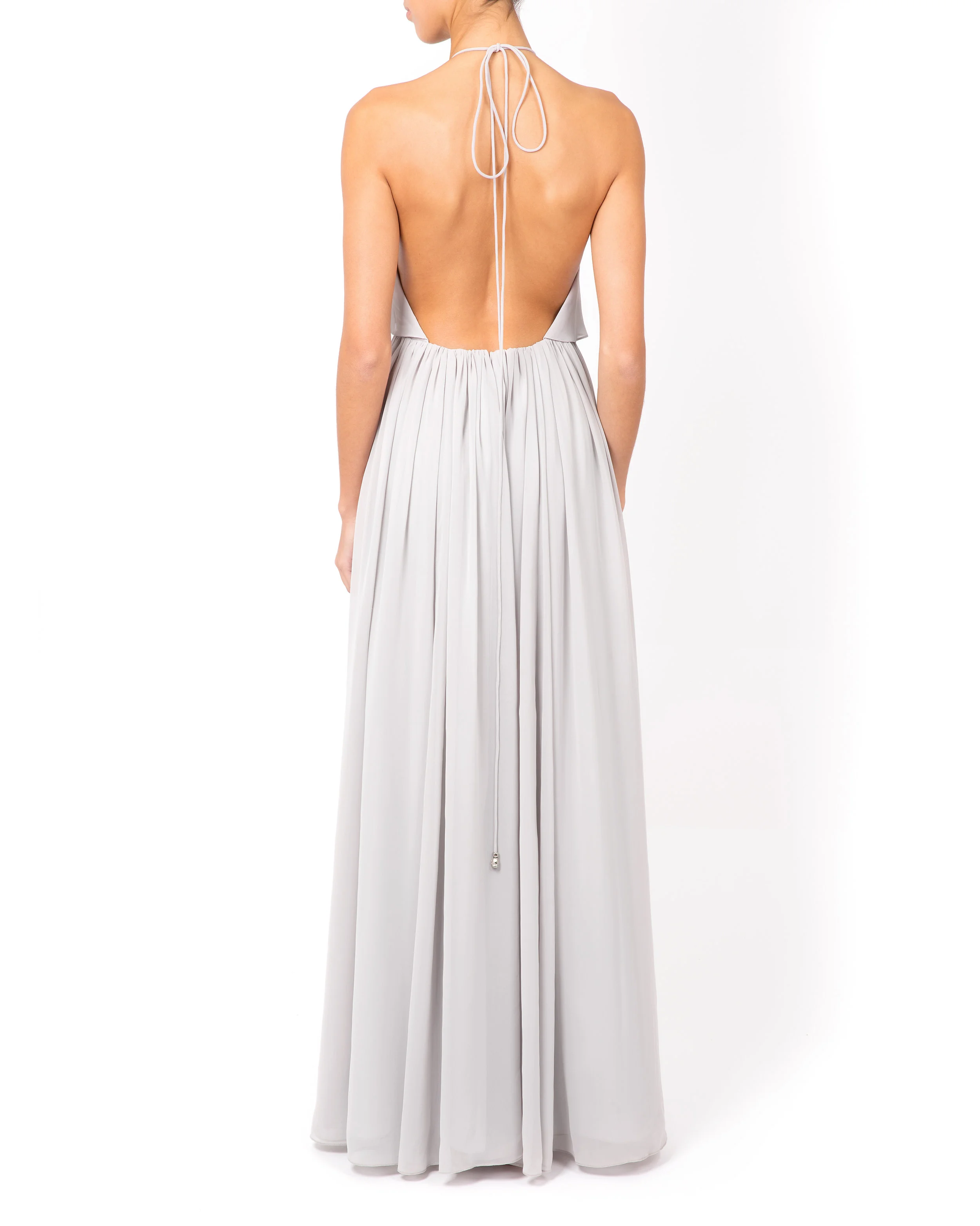 Back view of the halterneck formal dress in silver, with an open back and slender tie at the neck.