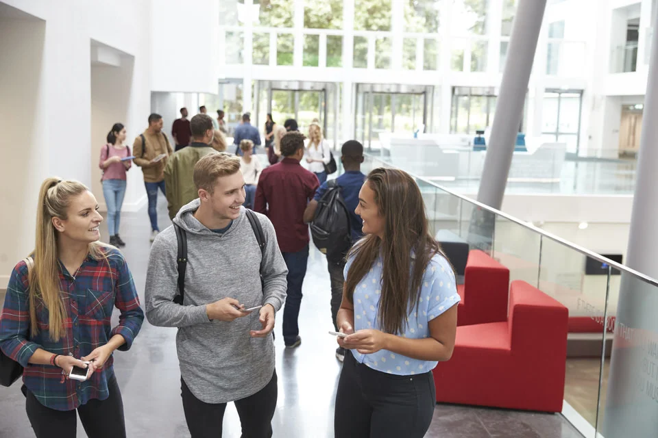 Students-holding-tablets-and-phone-talk-in-university-lobby-597958816_2125x1416 (1).jpeg