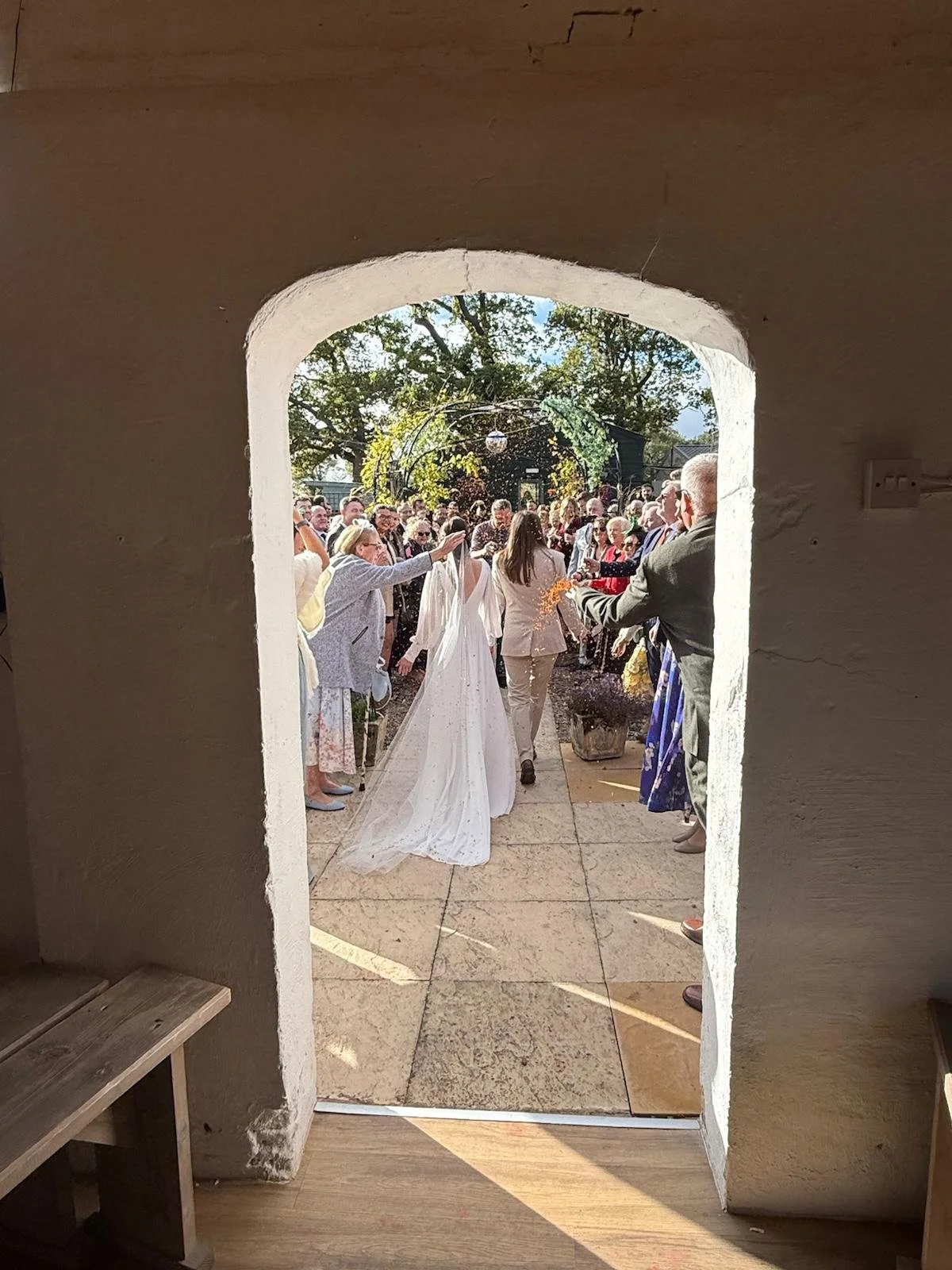 Holly &amp; Lydia exit the Stables into the Courtyard after the wedding ceremony at Stanford Farm in Shropshire