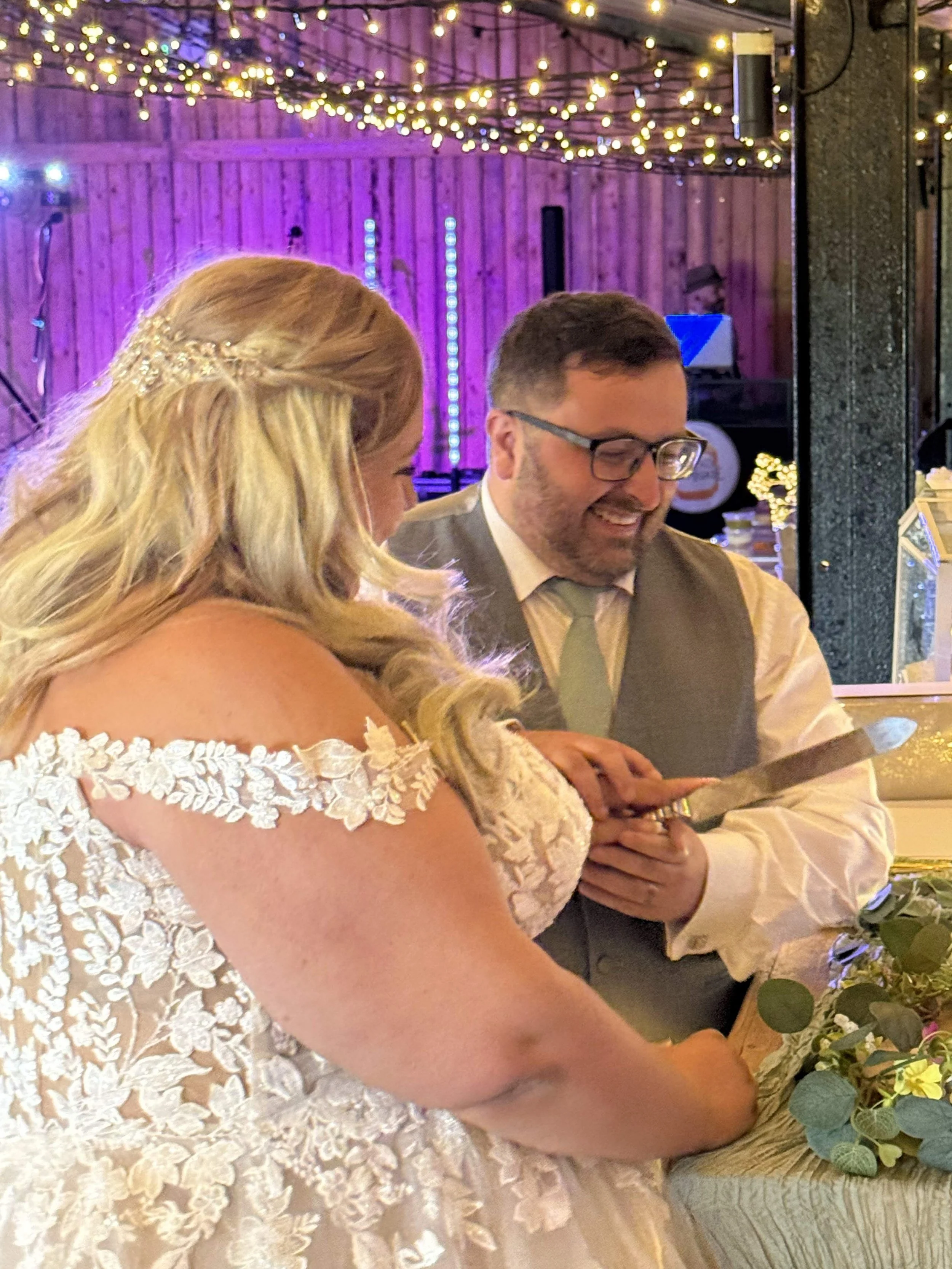 Cutting the cake at Charlie and Tom's Wedding at Stanford Farm
