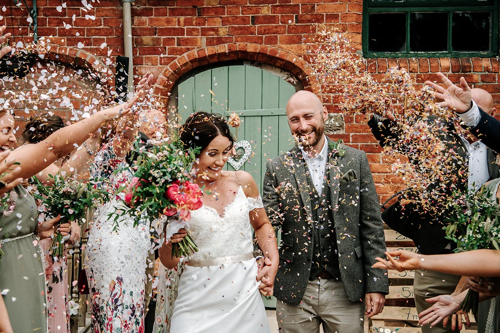 Wedding couple in the courtyard being showered with confetti at Stanford Farm