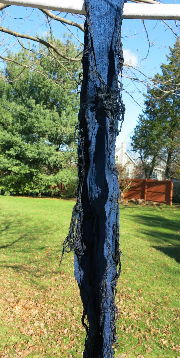 The cloth is oxidized after each dip in the indigo vat.