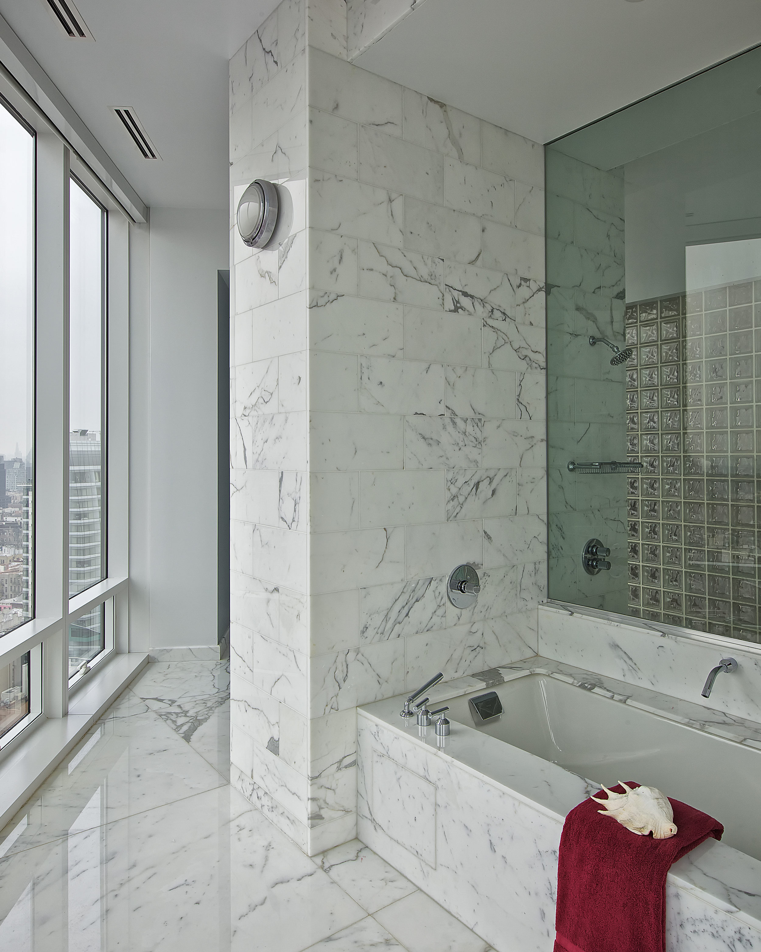   CHELSEA PENTHOUSE   Spend some time in the bathtub of this luxurious bathroom. With the proper lighting, materials, and accessories, it fits into the space perfectly. The glass wall allows the right brightness without ompromising privacy. The batht