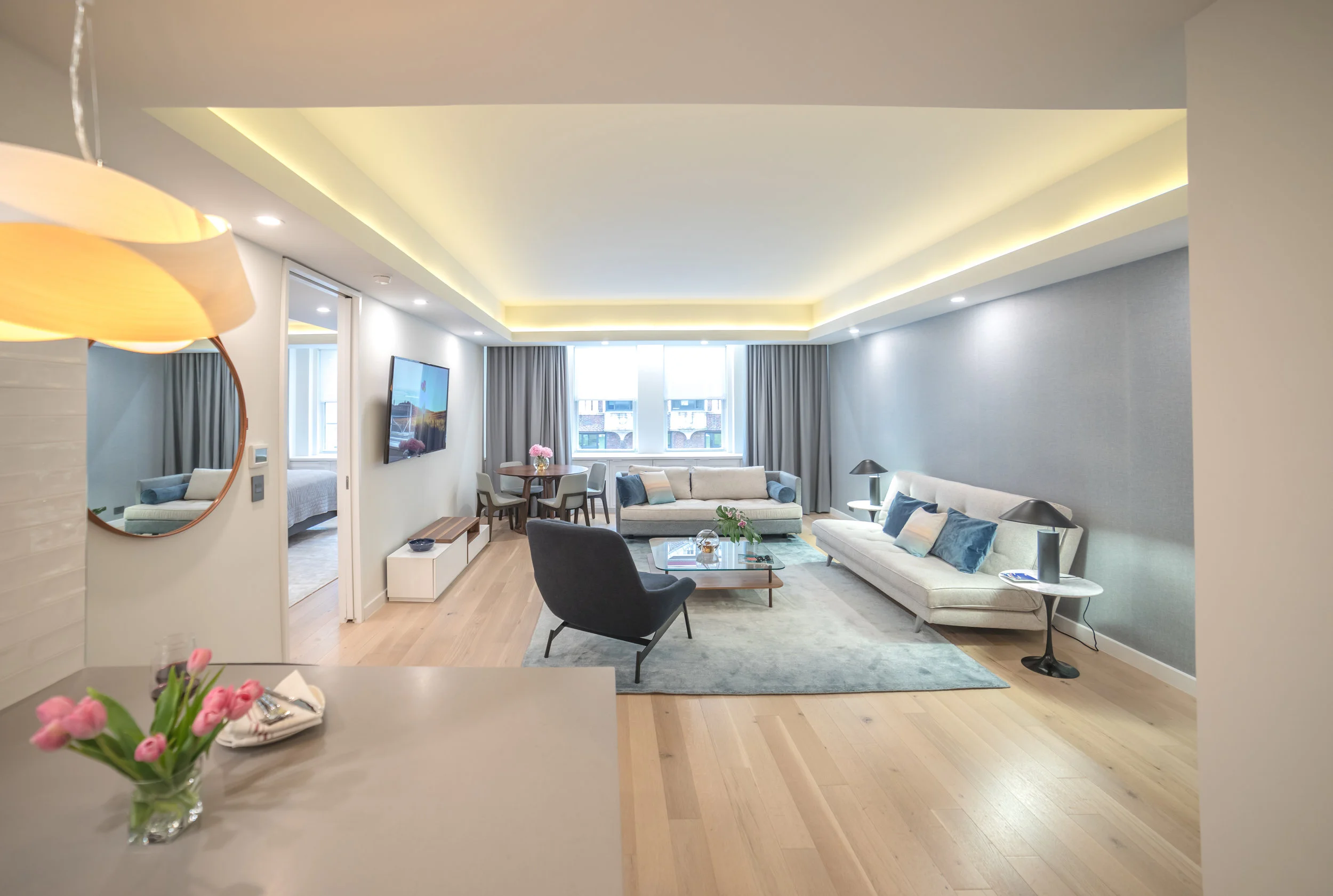 We replaced tired carpeting by a warm oak wood flooring throughout the whole space to create a cohesive decor and make the space feel larger. This was also a very durable and clean solution.