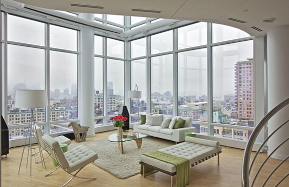  CHELSEA PENTHOUSE DUPLEX   The living room creates a serene environment through the subtle use of textures and furniture. An elegant horse statue and white chairs complement the glass walls and wooden flooring. The complete ambiance is visually appe