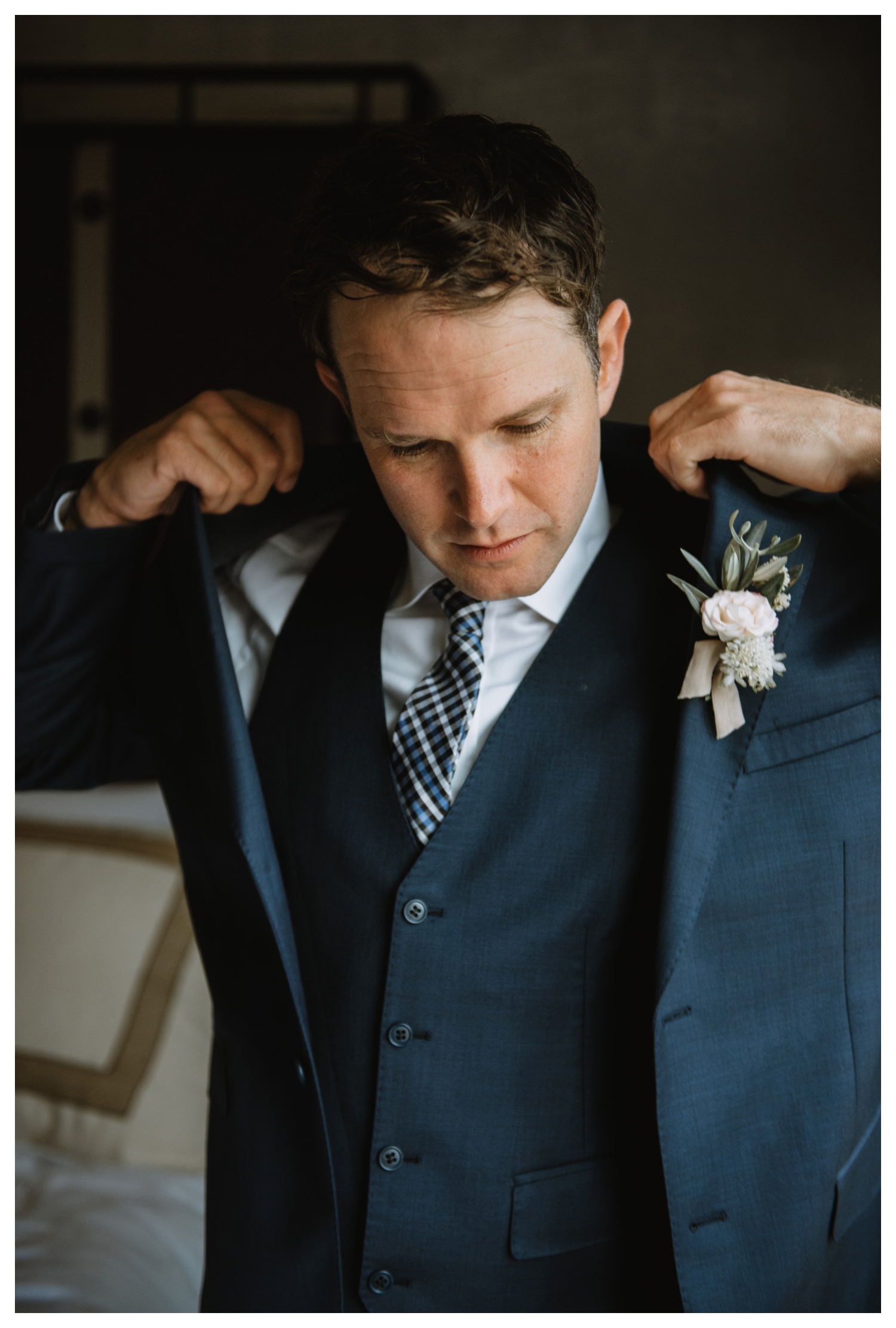 A groom adjusts his jacket on his wedding day