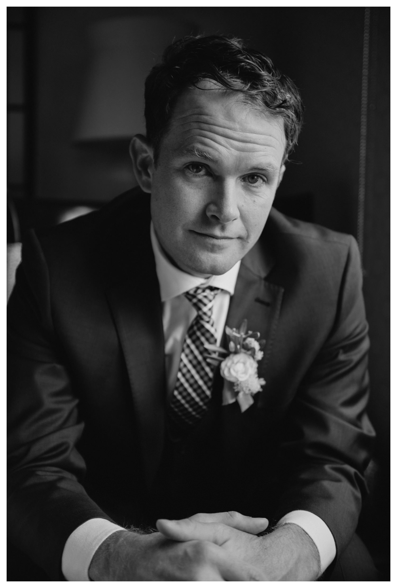 a groom stares calmly into the camera on his wedding day