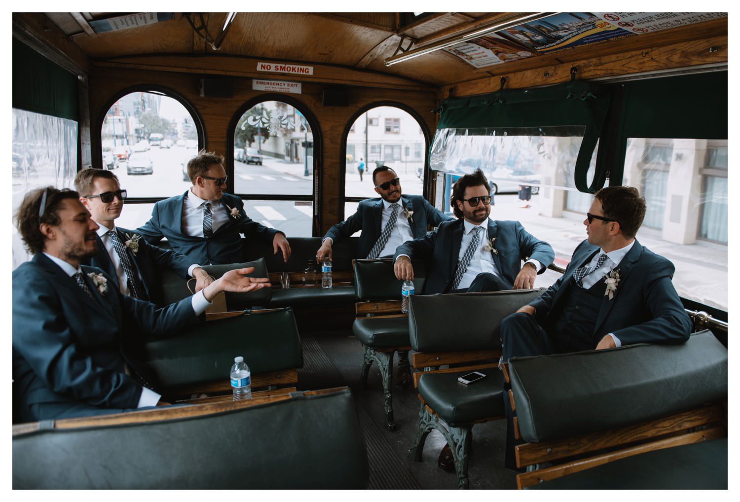 Groomsmen laugh on a bus on their way to the wedding