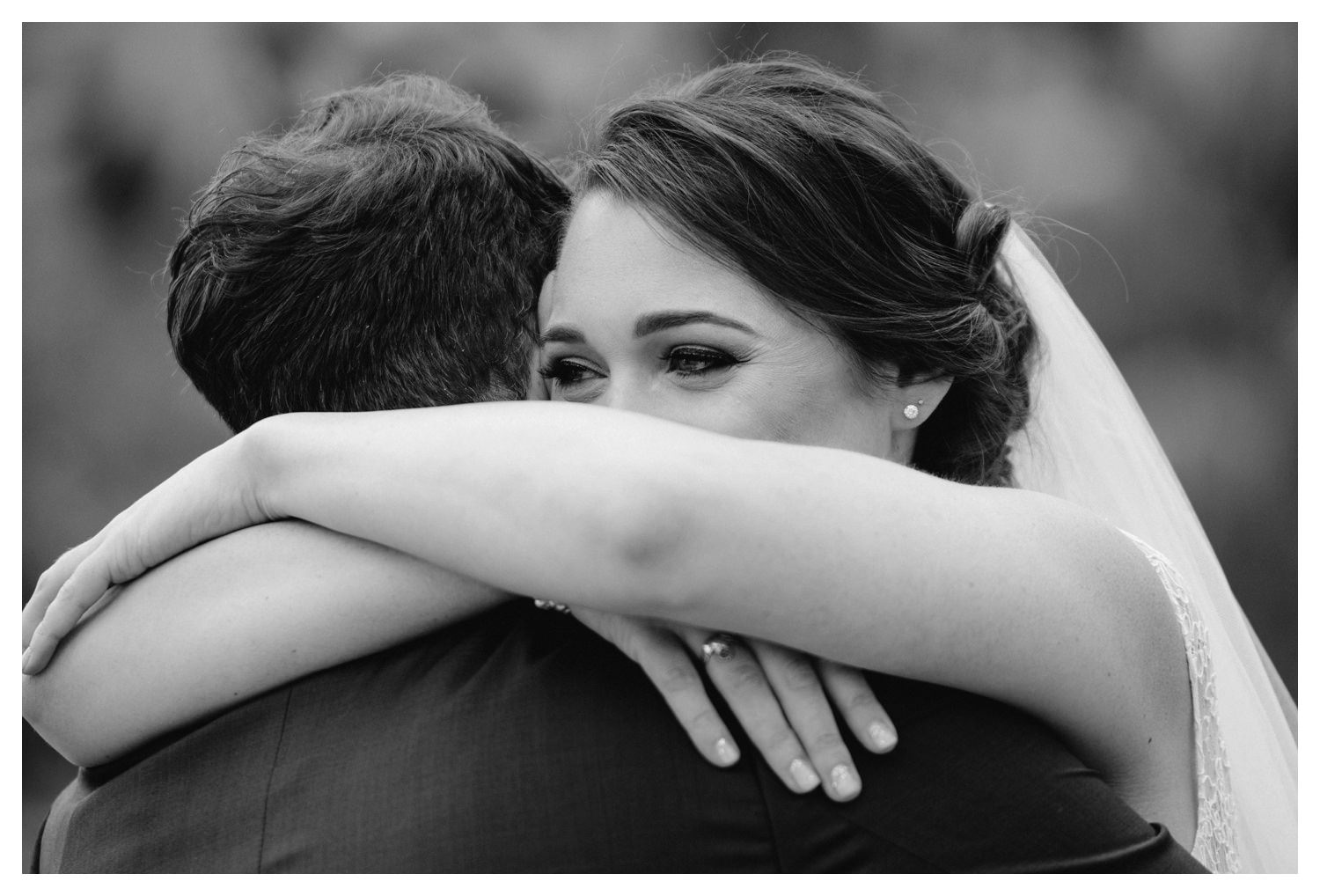a bride and groom embrace on their wedding day.