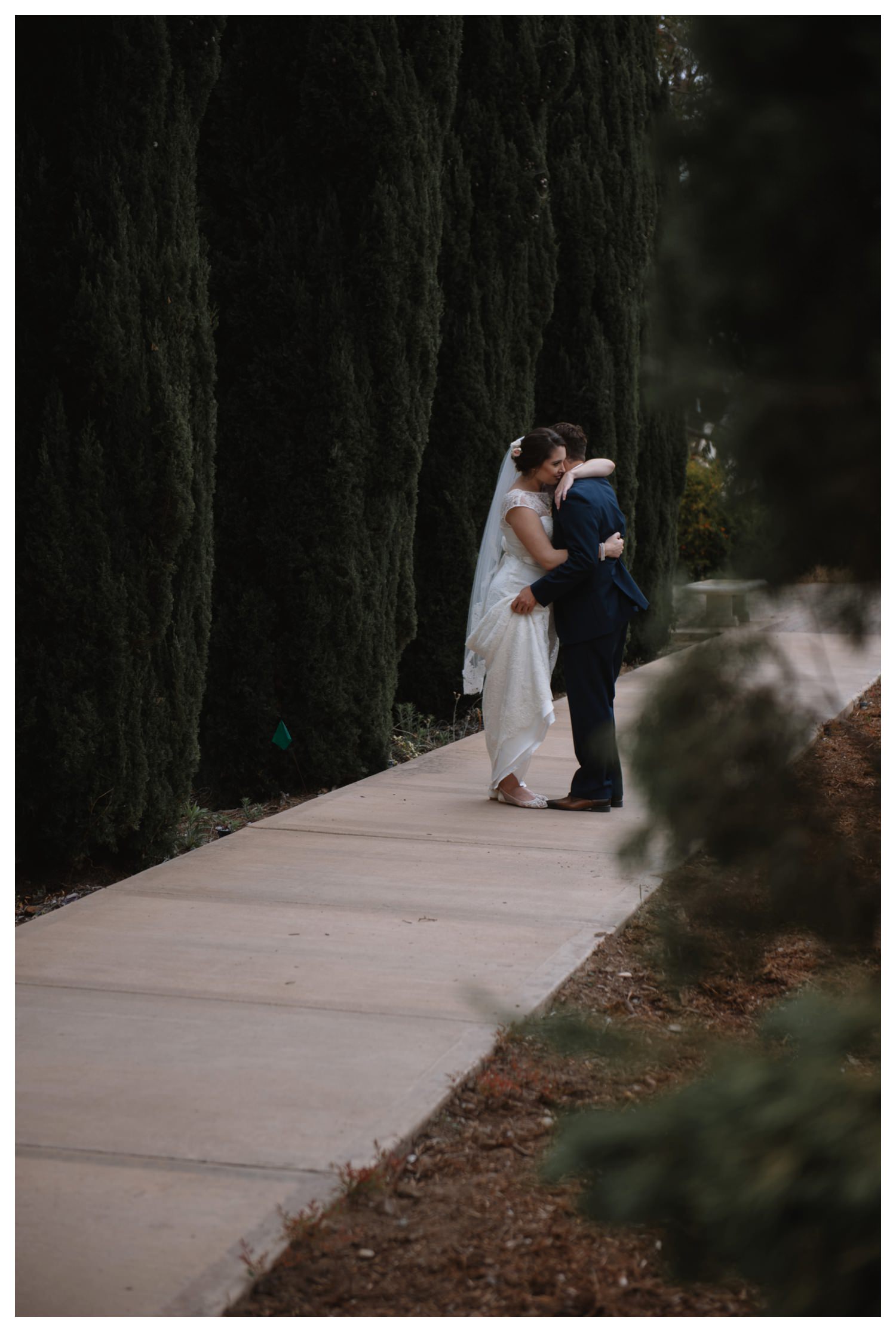 A wedding couple embrace at Balboa Park in San Diego