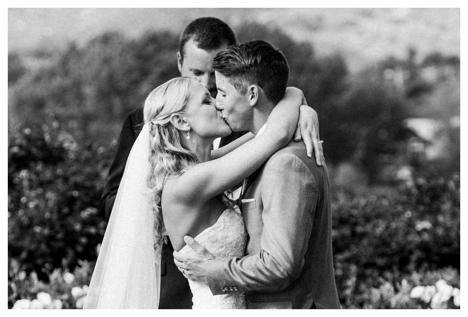 The happy couple kiss during their wedding ceremony in San Diego, CA.