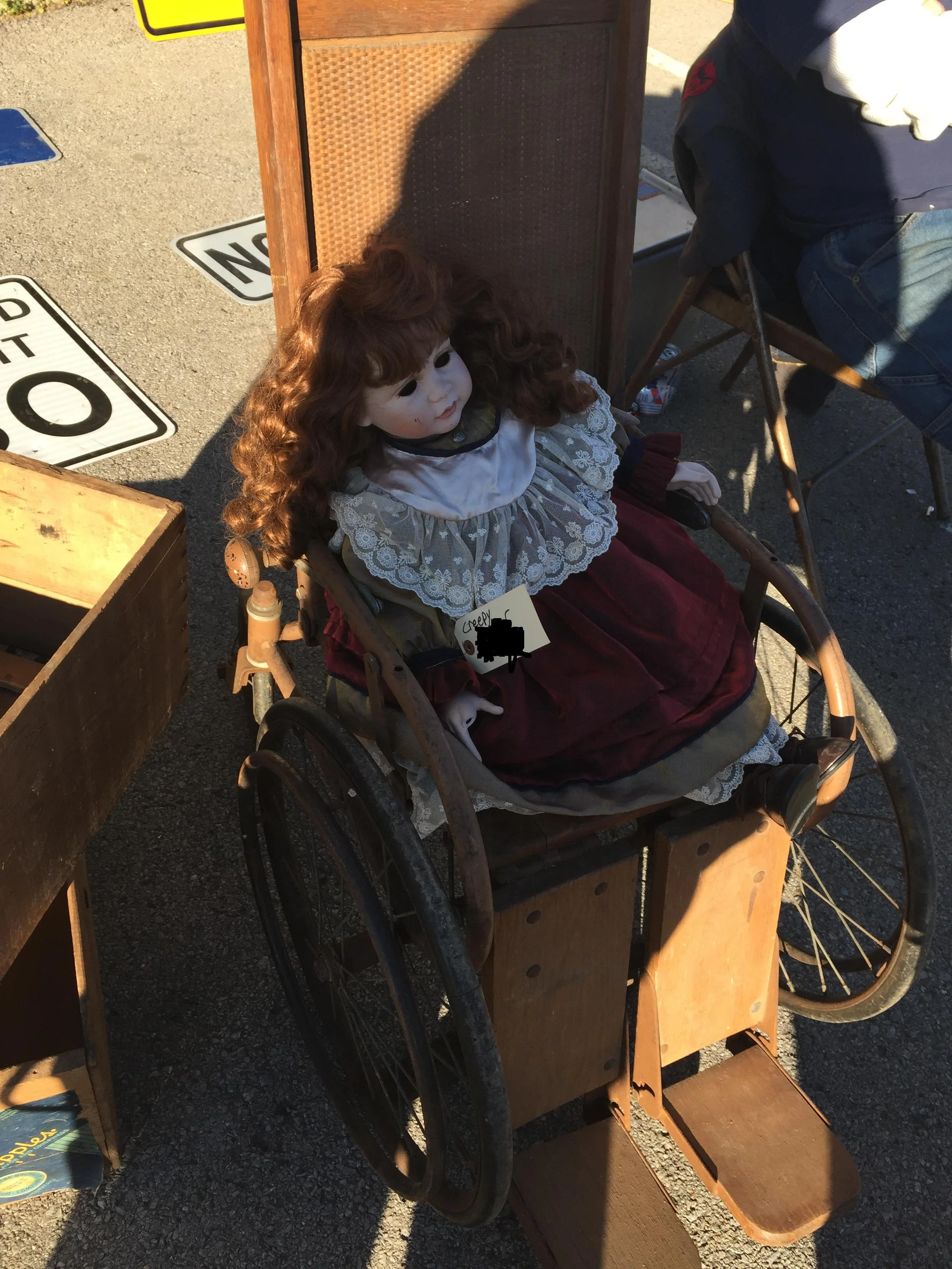 creepy eyeless doll in antique wheelchair.