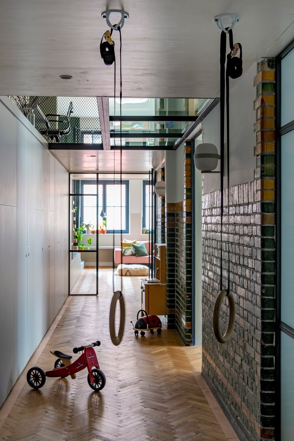 interieur+amsterdam+reportage+vtwonen+magazine+houten+vloer+hongaarse+punt+ringen+in+gang+om+te+spelen+doorkijk+stalen+deuren+verlichting+van+vibia+originele+bakstenen+van+oude+modeschool.jpg