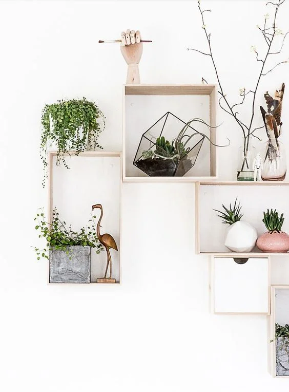 Een accentmuur: een rooster van hout met allerlei speelse attributen zoals planten, bloempotjes,...