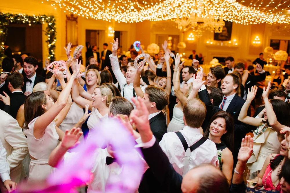 Guests dancing and celebrating together under warm lights