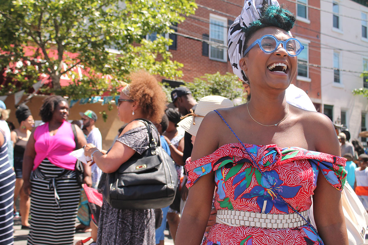 Rakia Reynolds, owner of Skai Blue Media, dons beautiful pastels and a contagious laugh at the Odunde Festival on South Street in Philadelphia, Pa. on Sunday June 12, 2016. Photography by Sofiya Ballin.
