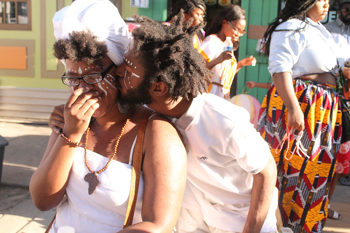 Traditional face paint and an unexpected kiss at the Odunde Festival on South Street in Philadelphia, Pa. on Sunday June 12, 2016. Photography by Sofiya Ballin.