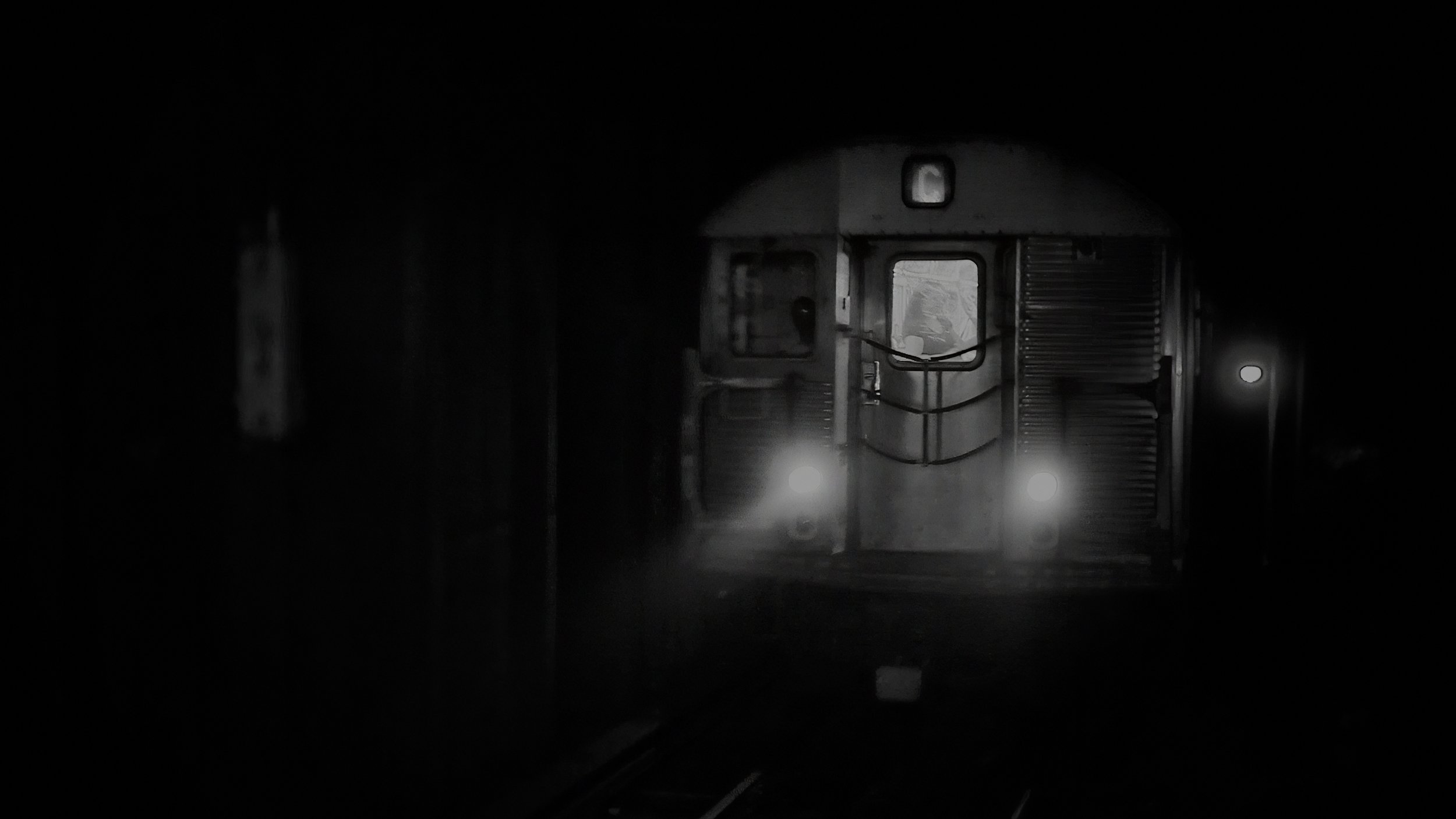 New York City subway train emerging from darkness in a black and white wedding film.