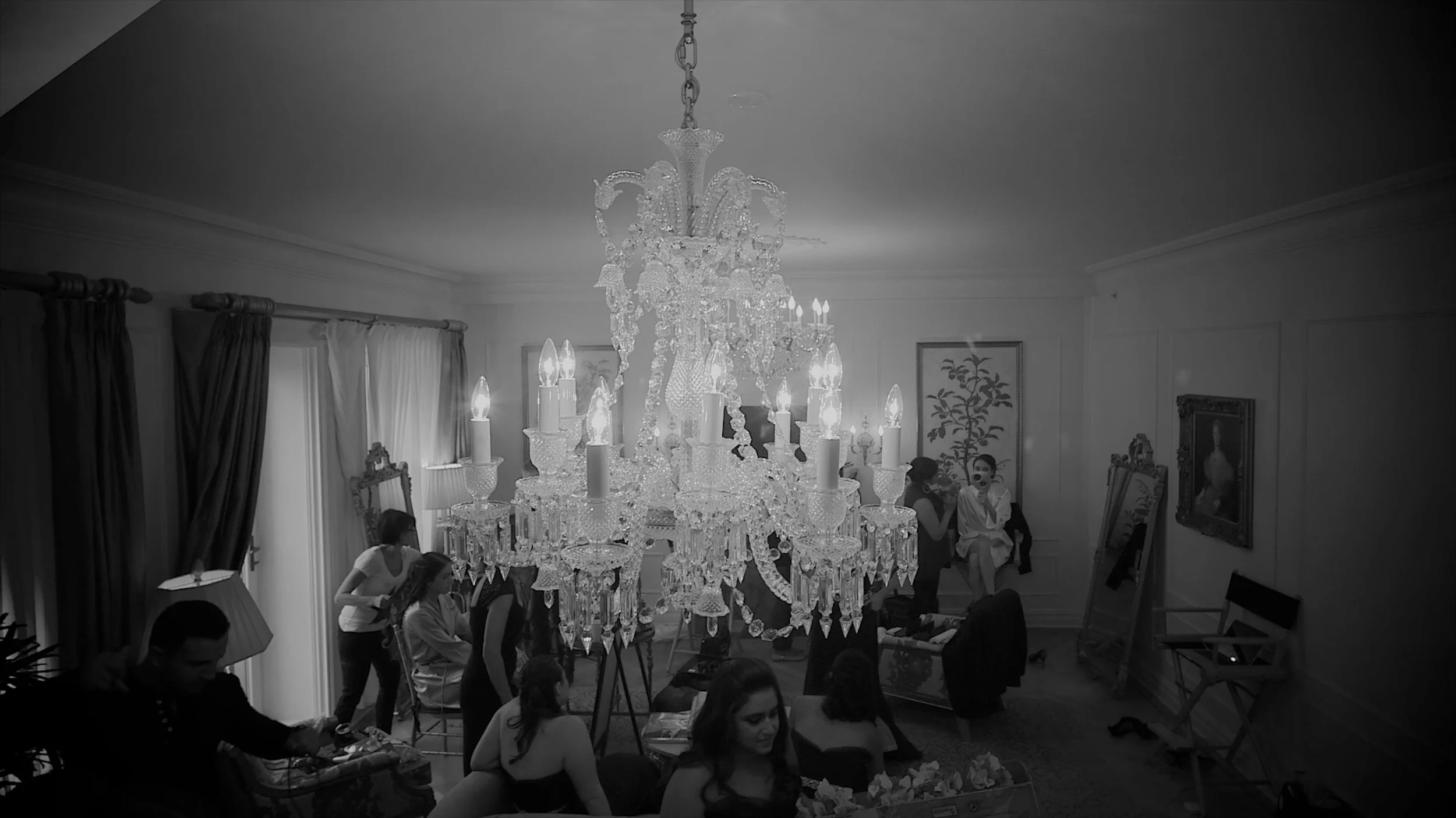 Wedding preparations unfolding beneath a crystal chandelier in a bridal suite at The Plaza Hotel.